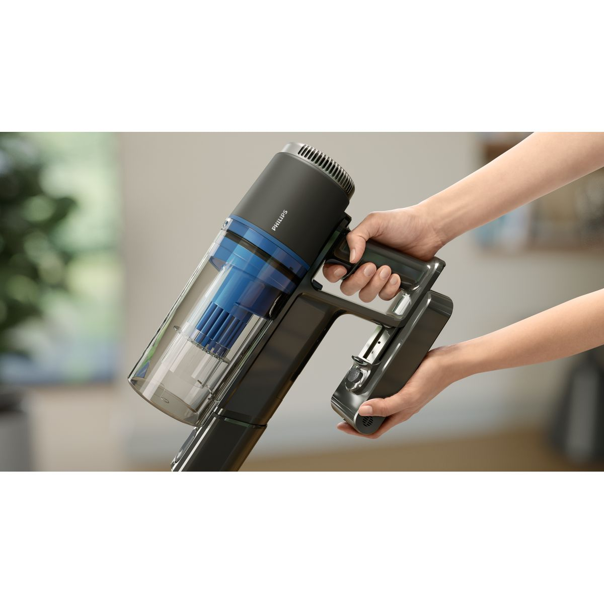 Eine Person hält einen schwarzen und blauen Philips-Staubsauger mit Händen. Der Staubsauger ist teilweise montiert.