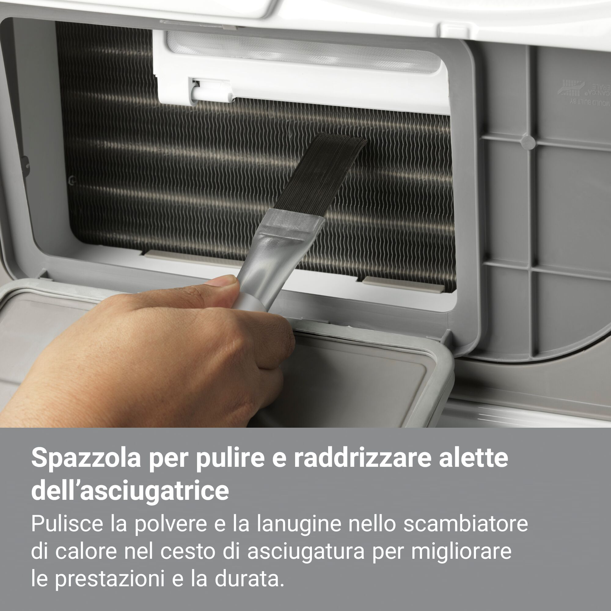 Una mano usa un cepillo para limpiar las aletas del intercambiador de calor de una secadora. Las aletas son metálicas.