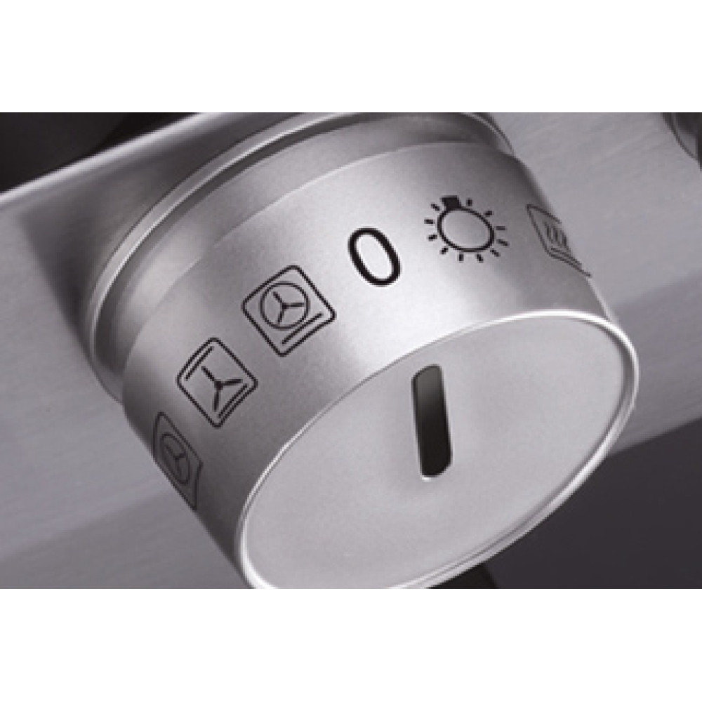 Zbliżenie srebrnego pokrętła piekarnika. Ma ikony funkcji piekarnika i oznaczenie '0'. Widoczna jest szczelina.