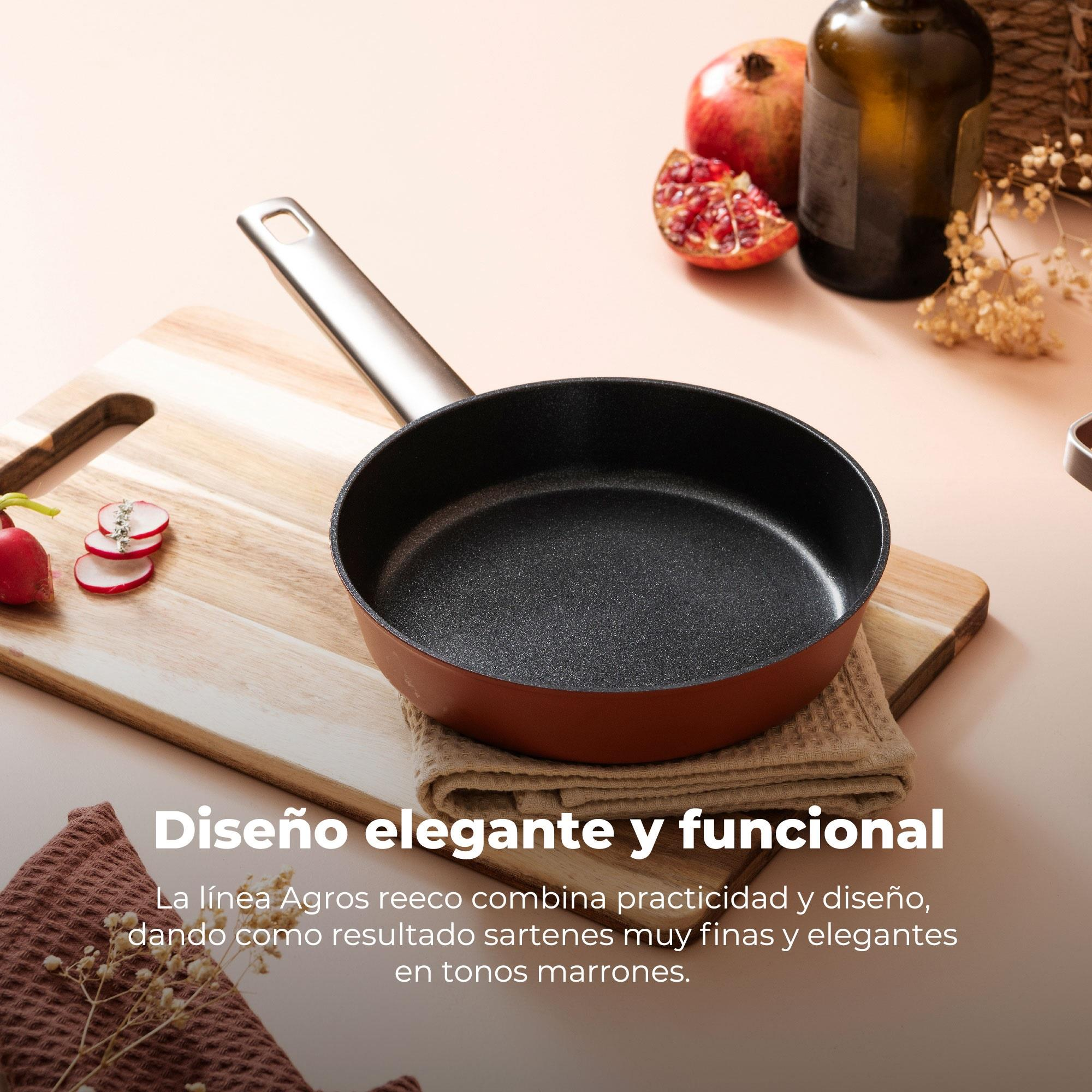 Sartén sobre tabla de madera. Rábanos, granada y botella en el fondo. Tonos marrones.