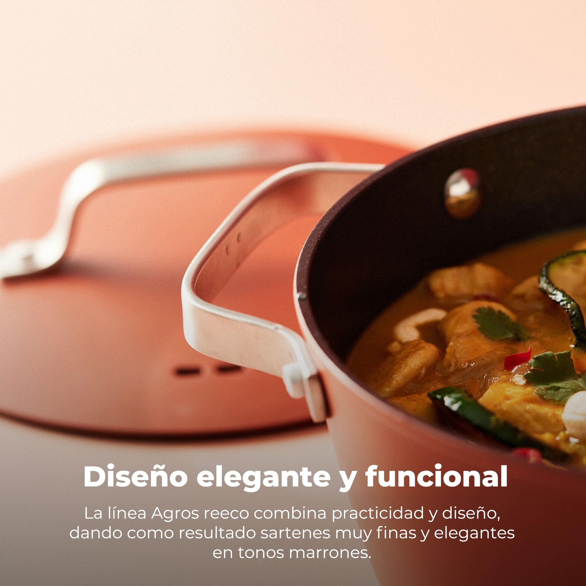 Una olla con comida. Enfoque en el contenido de la olla, mostrando verduras y salsa. La olla tiene asa y es marrón.