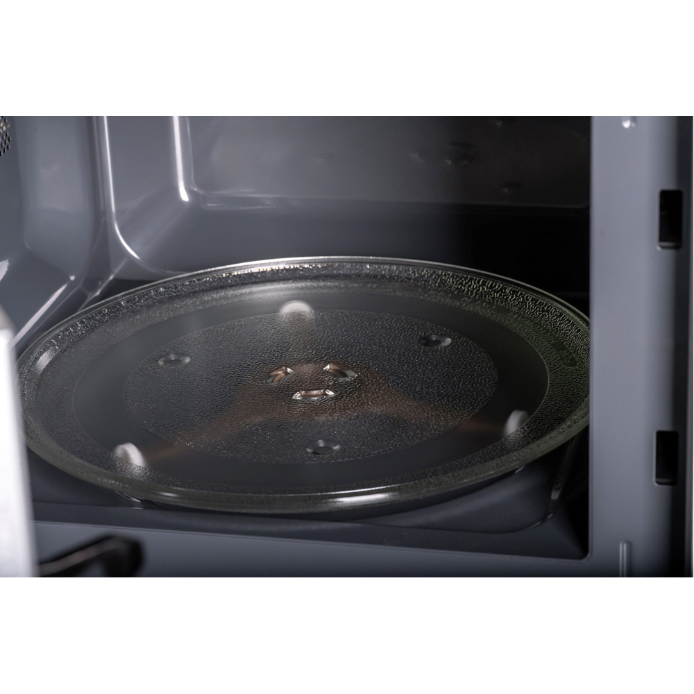 Wewnątrz kuchenki mikrofalowej widoczny jest przezroczysty szklany talerz. Wnętrze kuchenki jest ciemnoszare.