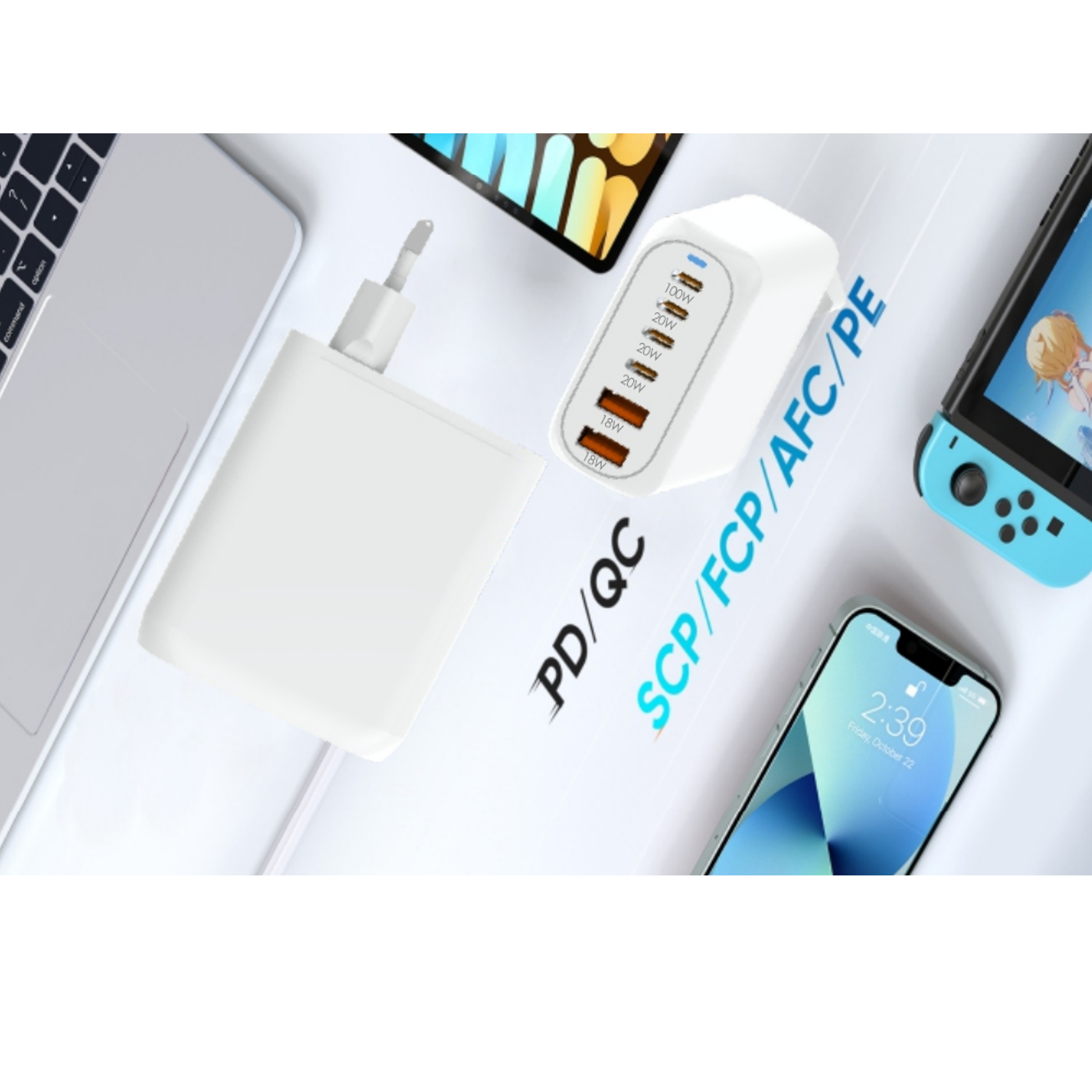 Cargador blanco, teléfono, portátil y consola de juegos sobre una superficie blanca. El teléfono muestra la hora.