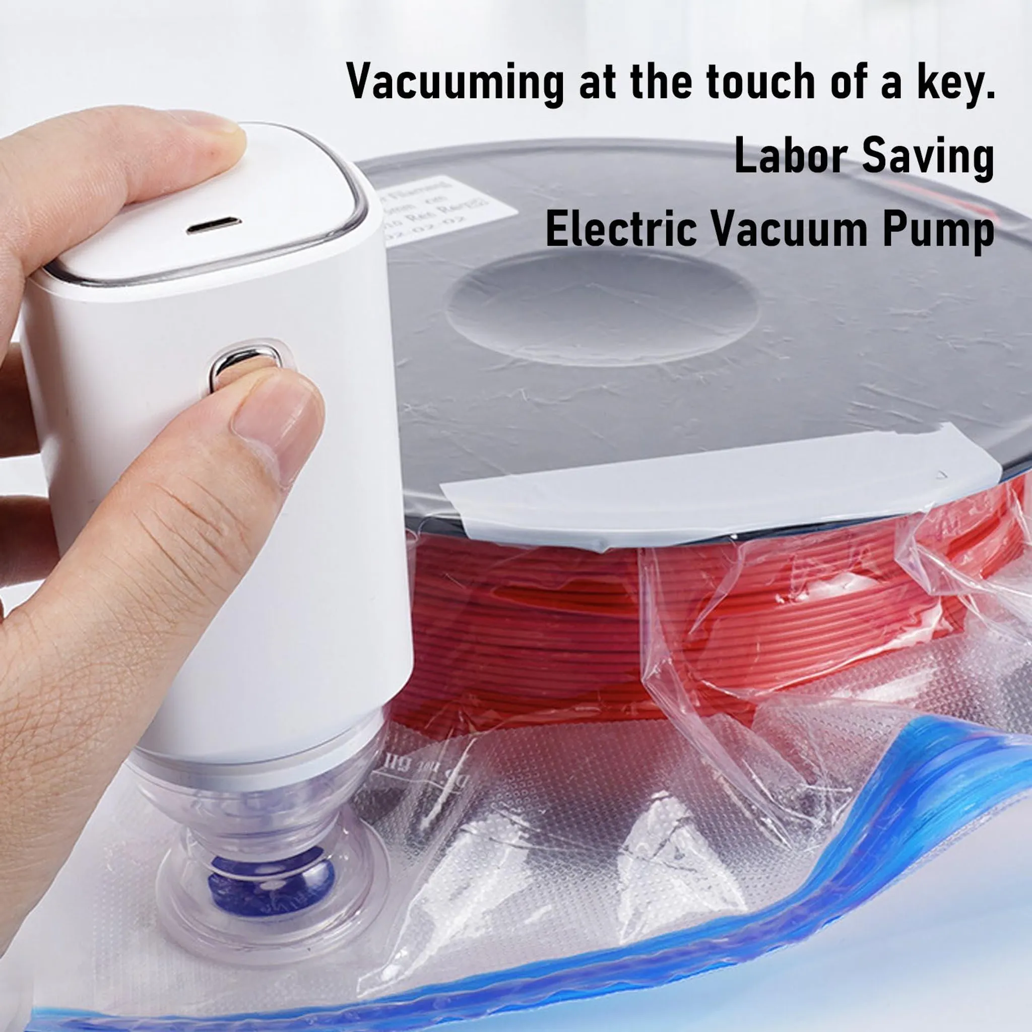 Eine Hand bedient eine weiße elektrische Vakuumpumpe. Ein rotes Objekt befindet sich in einer Tüte. Text: 'Vakuumieren auf Knopfdruck'.