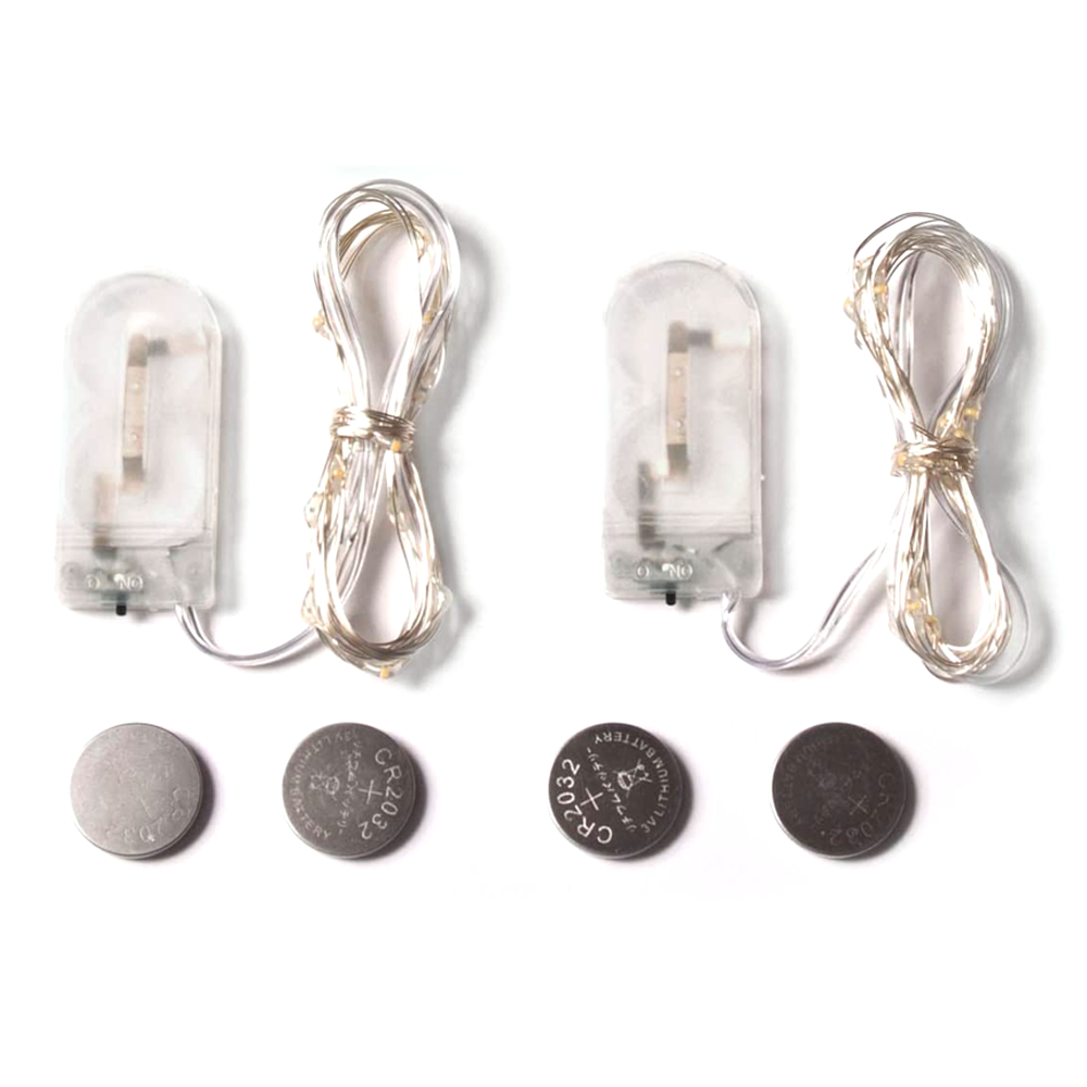 Zwei Sets Lichterketten, jeweils mit Batteriegehäuse und CR2032 Batterie auf weißem Hintergrund.