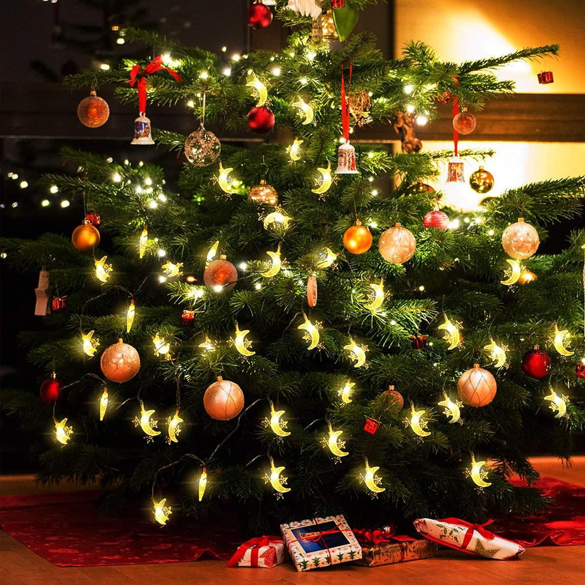 Ein geschmückter Weihnachtsbaum mit Ornamenten, Lichtern und Geschenken an der Basis. Ornamente umfassen Kugeln, Glocken und sternförmige Lichter.