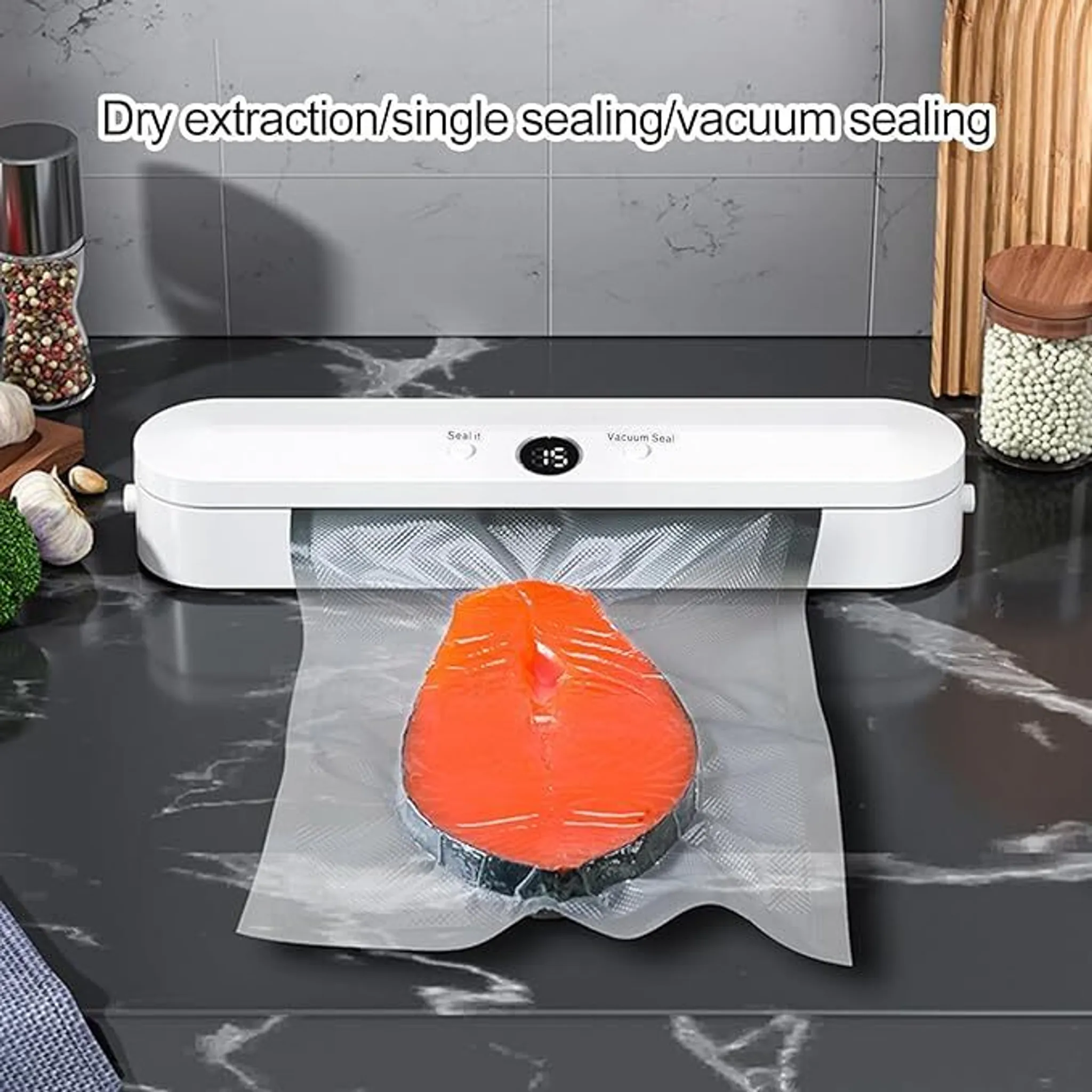 Ein weißer Vakuumierer mit einem Lachssteak in einem Beutel. Küchenartikel im Hintergrund.
