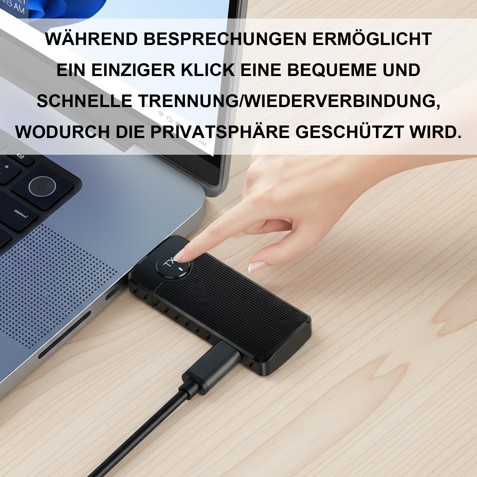 Eine Hand drückt eine Taste auf einem schwarzen Gerät, das mit einem Laptop verbunden ist.