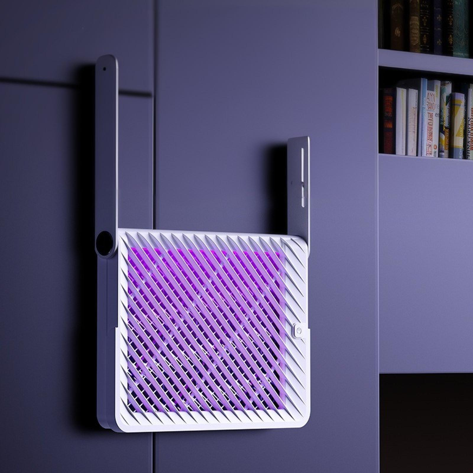 Ein weißer Insektenvernichter mit lila Licht, an einer lila Wand montiert. Bücherregal rechts.