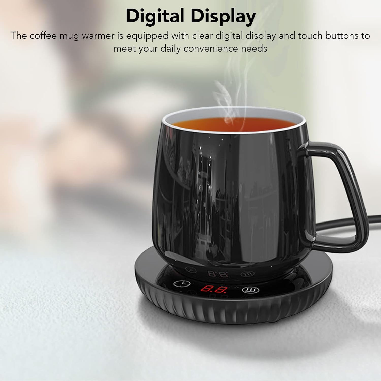 Eine schwarze Kaffeetasse steht auf einem Wärmer mit digitaler Anzeige. Die Tasse enthält ein heißes Getränk, und Dampf steigt auf.