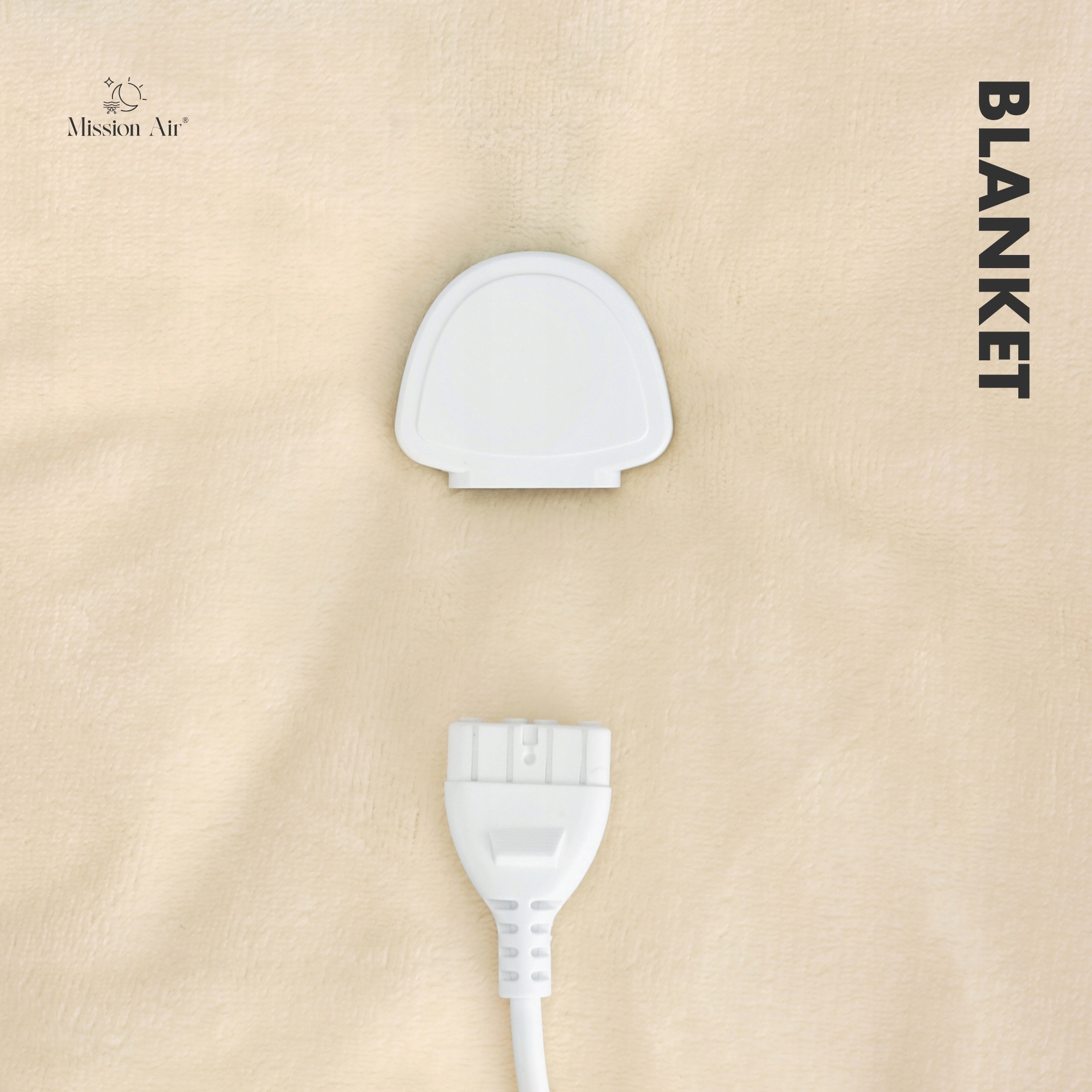Kremowy koc z białym złączem i wtyczką. Słowo BLANKET jest napisane pionowo. Logo Mission Air u góry po lewej.