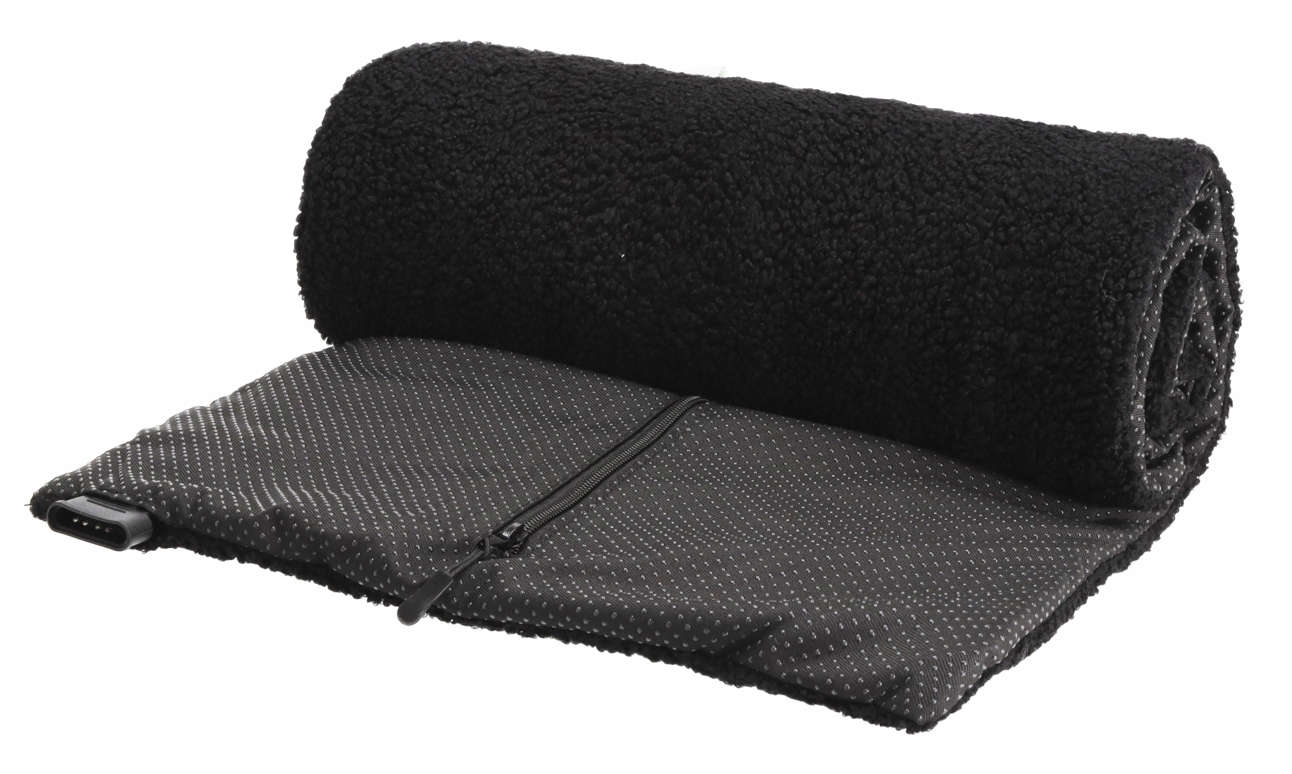 Zwinięty czarny koc leży na szarej, teksturowanej podstawie z zamkiem błyskawicznym. Koc ma puszystą teksturę.