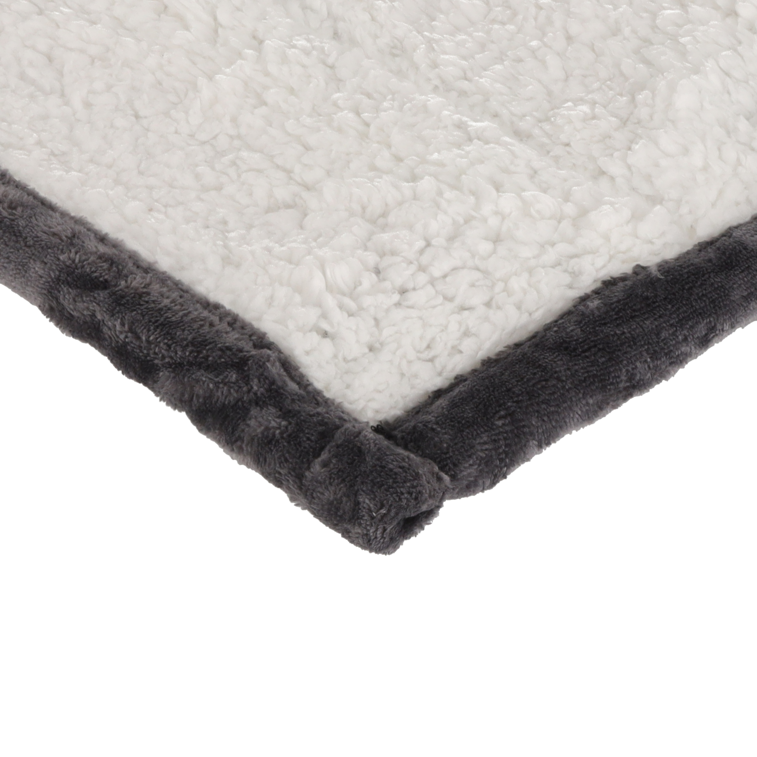 Zbliżenie białego, puszystego koca z ciemnoszarą lamówką. Lamówka tworzy róg.