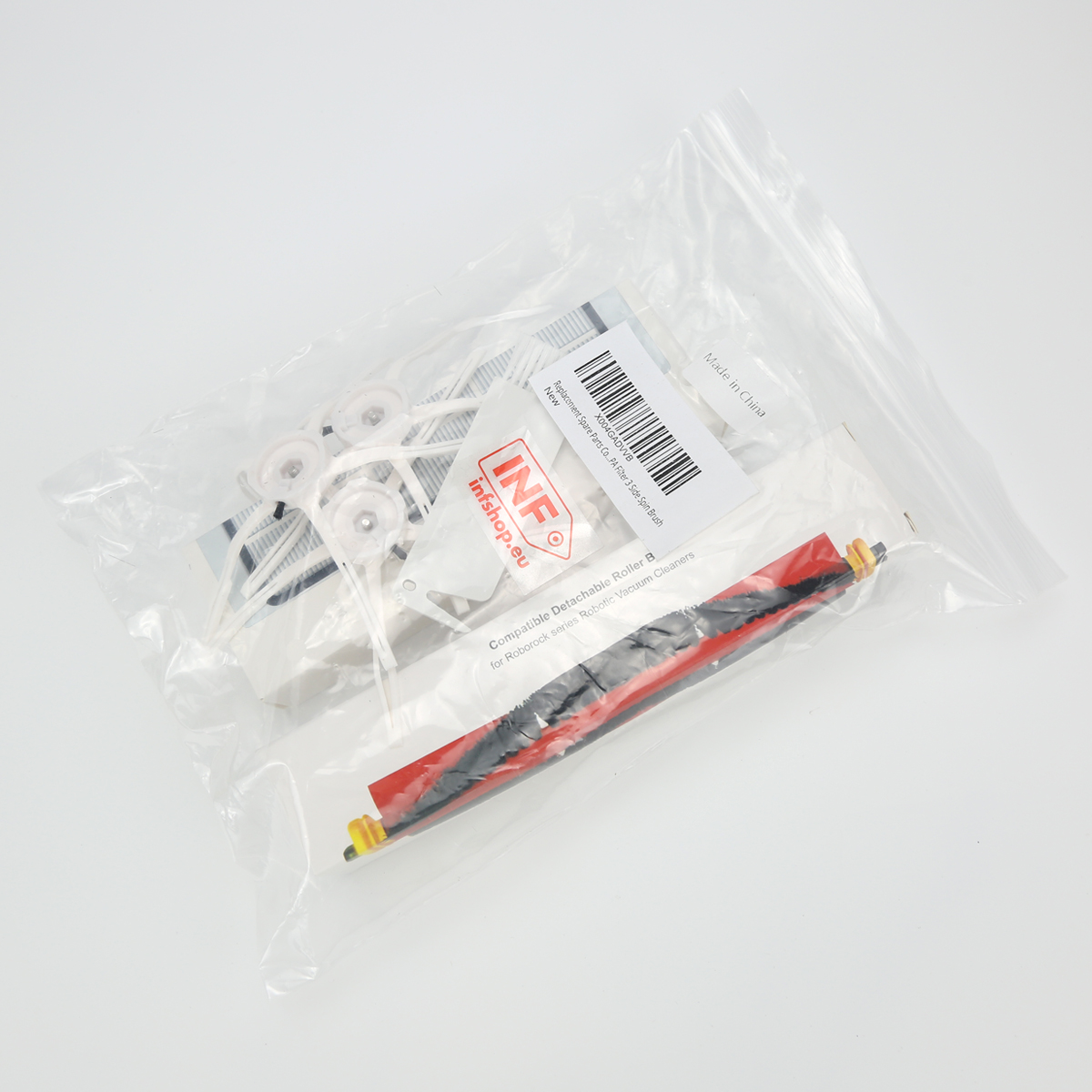 Przezroczysta plastikowa torba zawierająca części do odkurzacza, w tym szczotkę rolkową i filtry, na białej powierzchni.