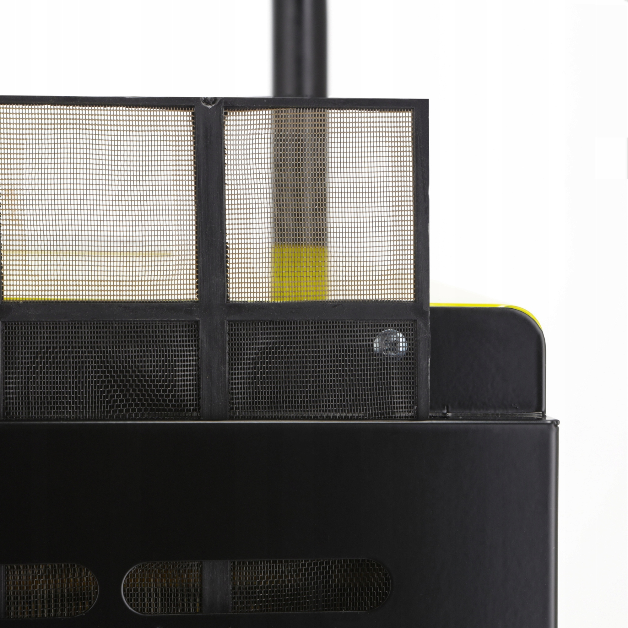 Zbliżenie czarnego obiektu pokrytego siatką z żółtym wnętrzem na białym tle.