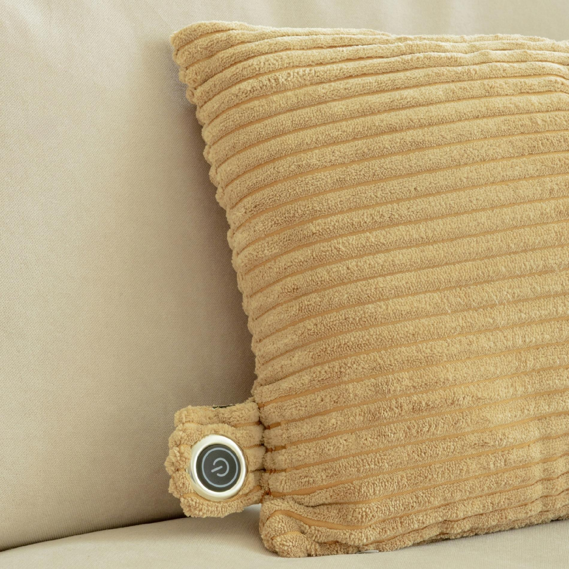 Beżowa poduszka sztruksowa z przyciskiem zasilania na beżowej powierzchni. Poduszka jest częściowo widoczna.