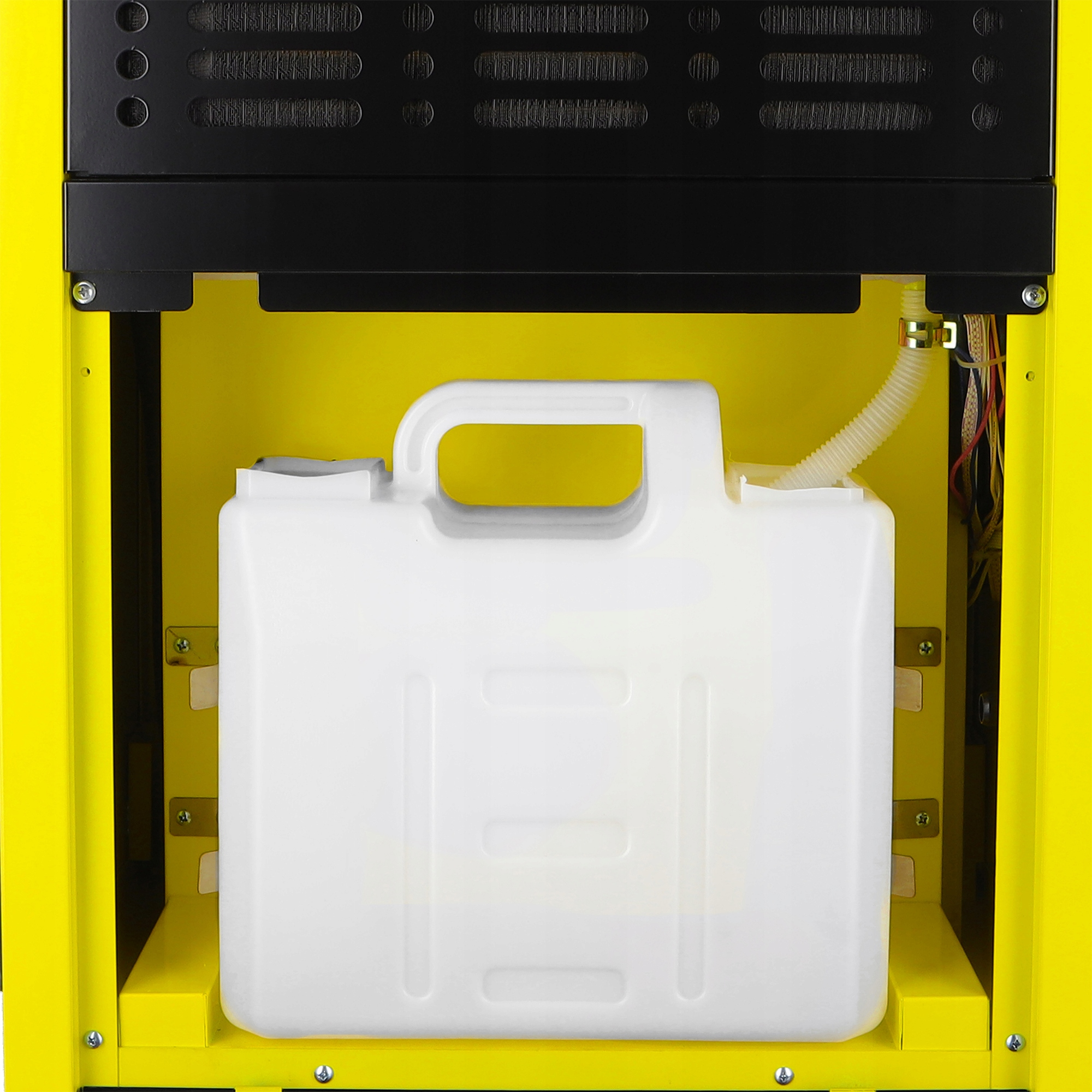 Biały pojemnik z uchwytem znajduje się w żółtej maszynie z czarnym blatem. Do pojemnika podłączony jest elastyczny przewód.