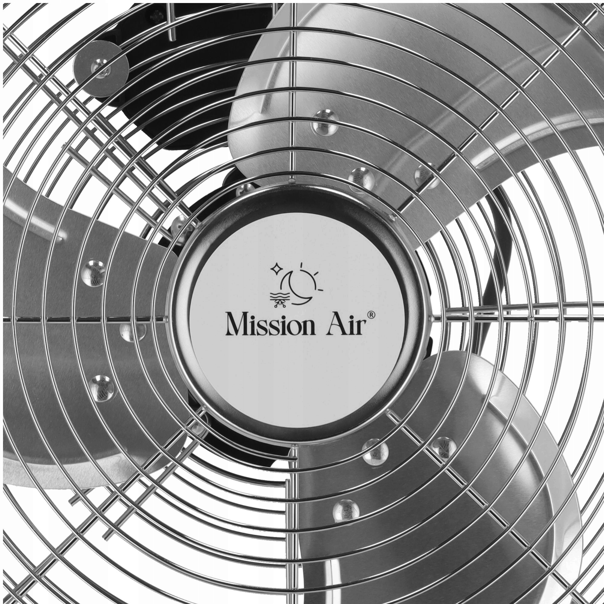 Zbliżenie srebrnego wentylatora z centralnym logo: Mission Air. Wentylator posiada metalową osłonę ochronną.