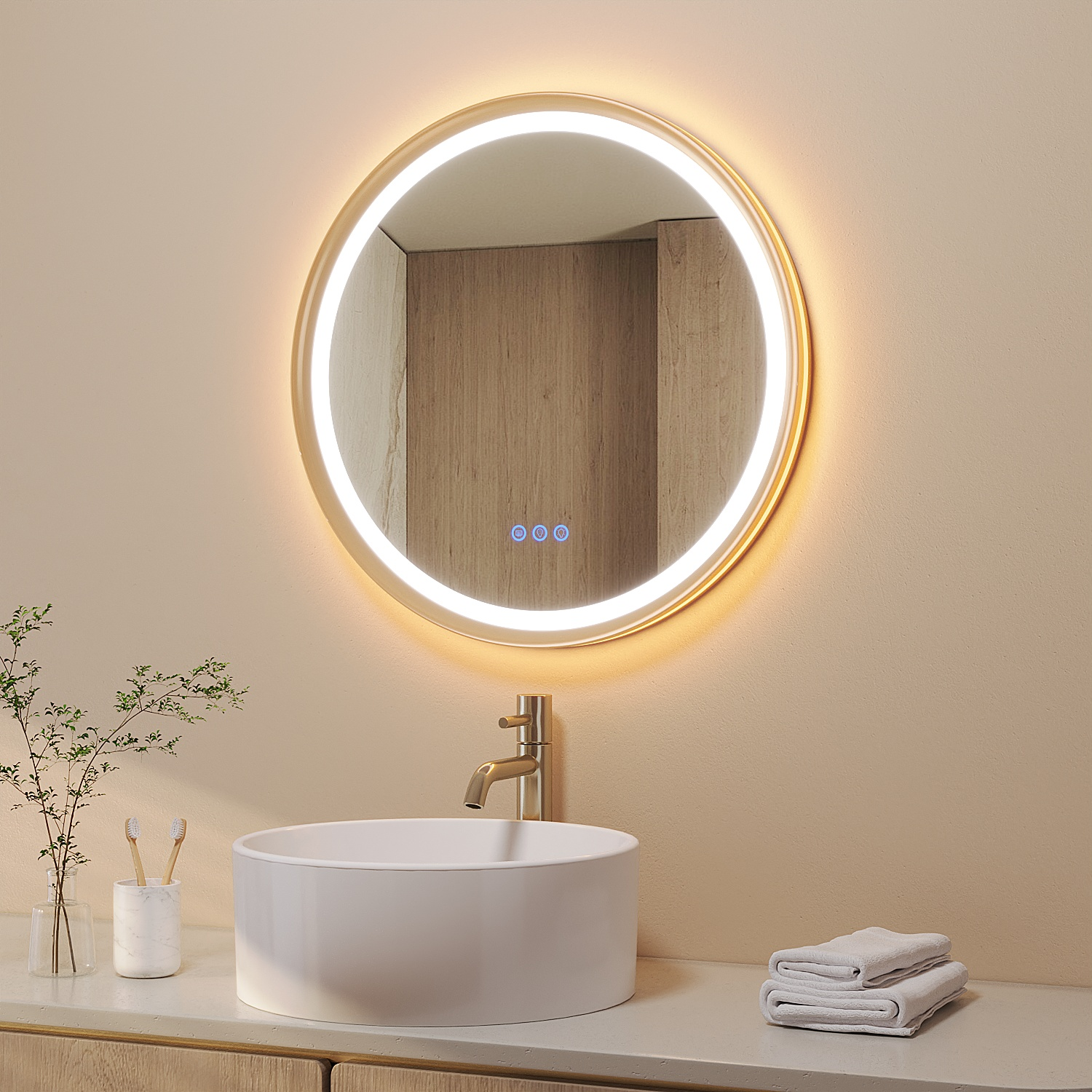 Badezimmer mit rundem, beleuchtetem Spiegel, Waschbecken, Wasserhahn, Handtüchern und einer Pflanze. Neutrale Töne dominieren.