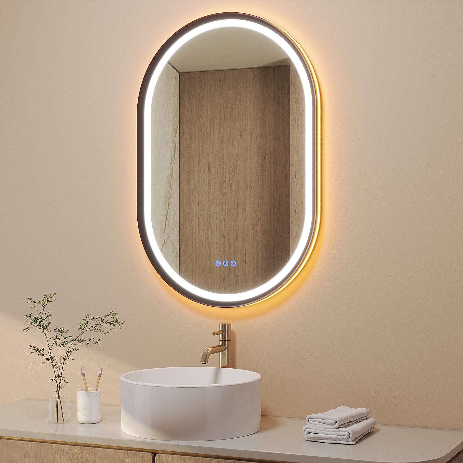 Ovaler beleuchteter Spiegel über einem weißen Waschbecken mit goldener Armatur. Handtücher und Toilettenartikel auf einer Theke im beigen Badezimmer.