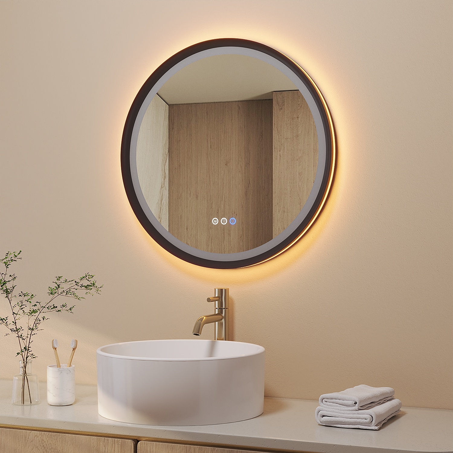 Ein modernes Badezimmer mit rundem Spiegel, weißem Waschbecken, goldener Armatur und zwei Handtüchern. Pflanze und Zahnbürsten auf der Theke.