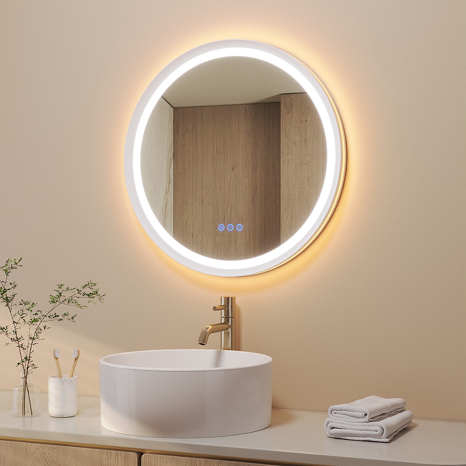 Ein modernes Badezimmer mit rundem beleuchtetem Spiegel, weißem Waschbecken und Handtüchern. Es gibt auch Pflanzen und einen Wasserhahn.