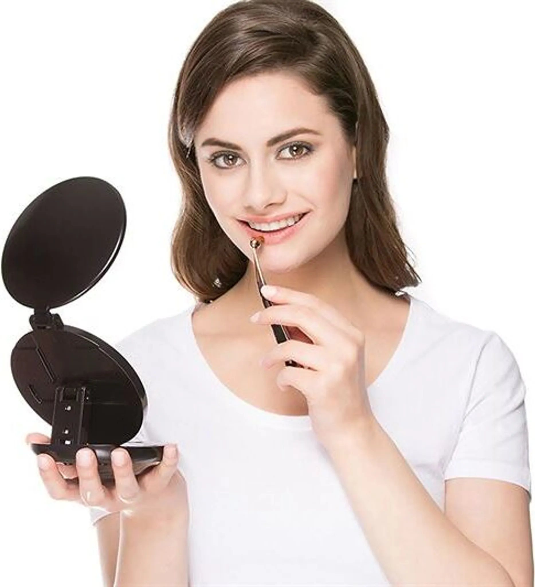 Eine Frau trägt mit einem Pinsel Make-up auf und benutzt einen Kompaktspiegel. Sie trägt ein weißes Hemd und lächelt. Der Hintergrund ist weiß.