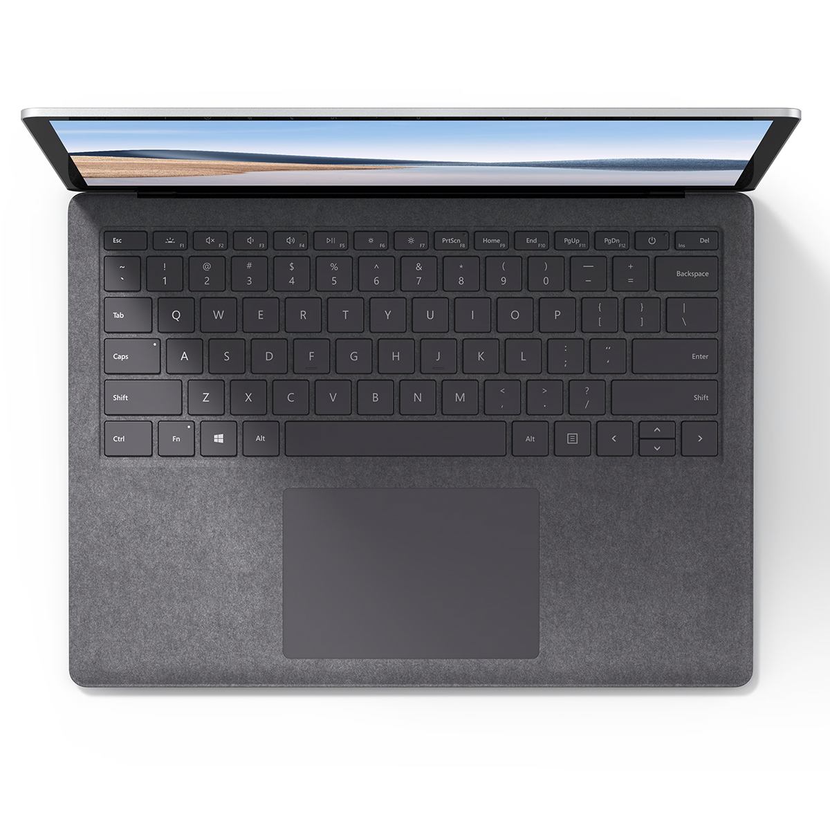 Laptop, top view. Keyboard is in focus. Screen displays a landscape. The device is on a white surface.