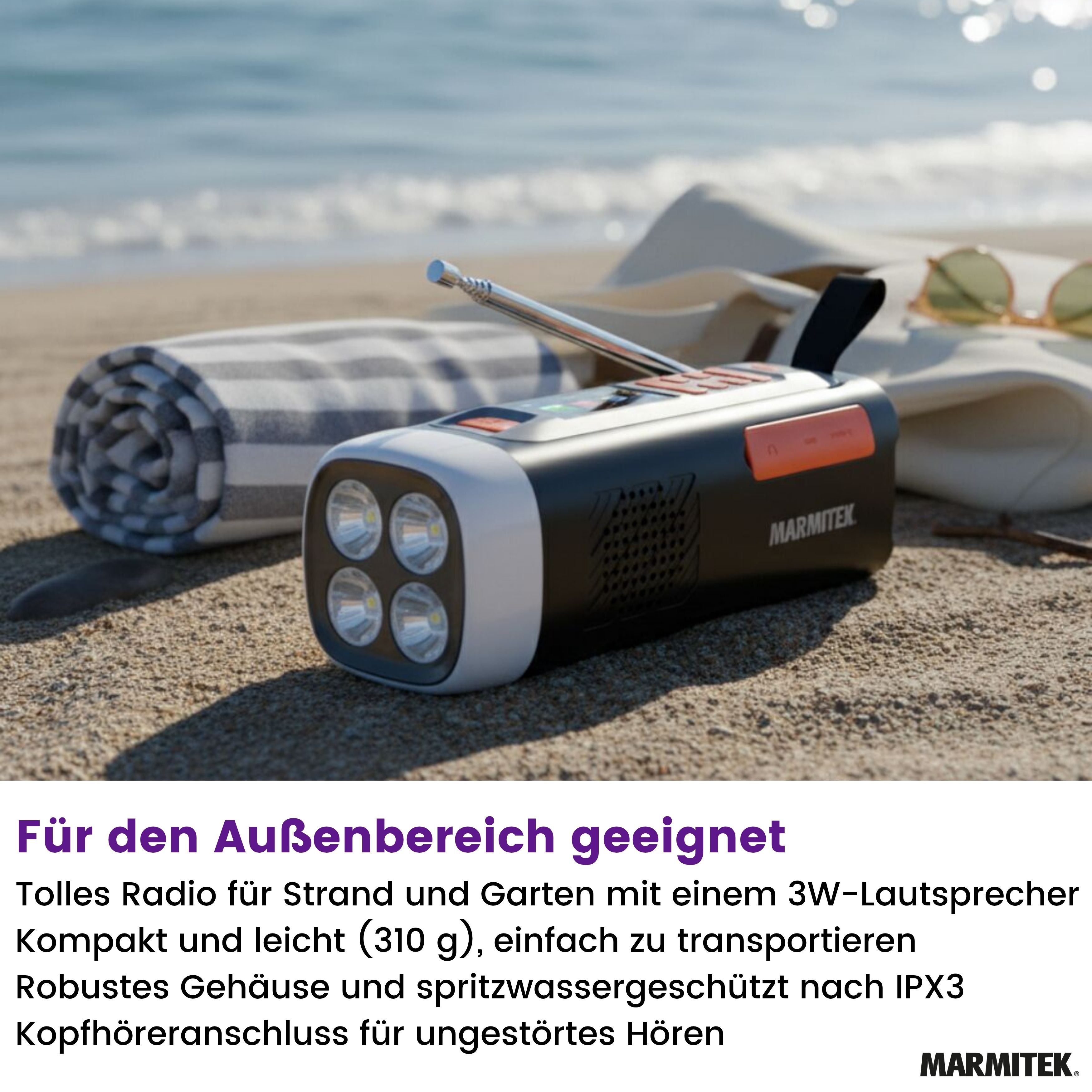 A radio with a flashlight is on the sand near a beach towel, sunglasses, and the ocean in the background.
