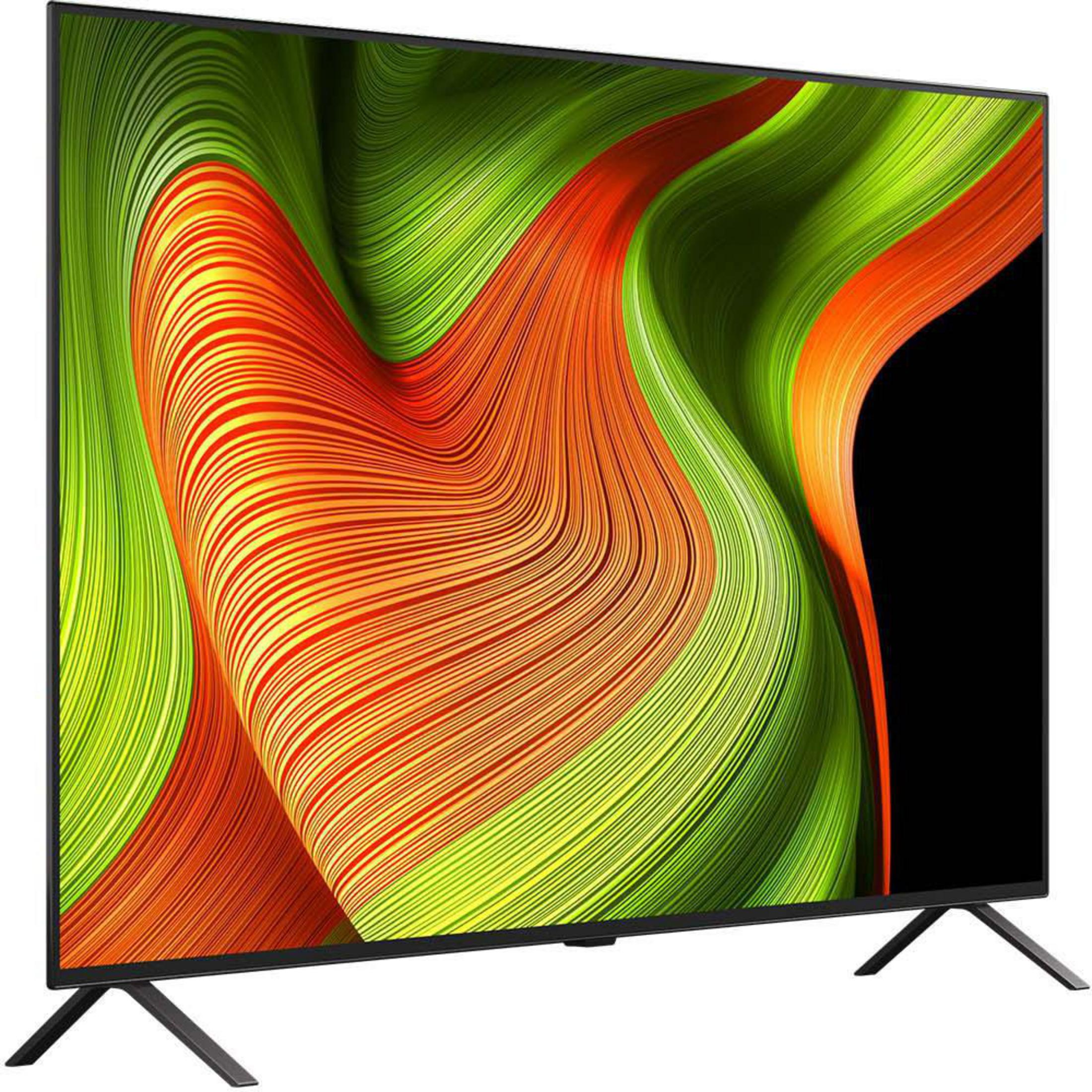 Un téléviseur à écran plat affiche un motif abstrait coloré de vert, orange et noir, monté sur un support.