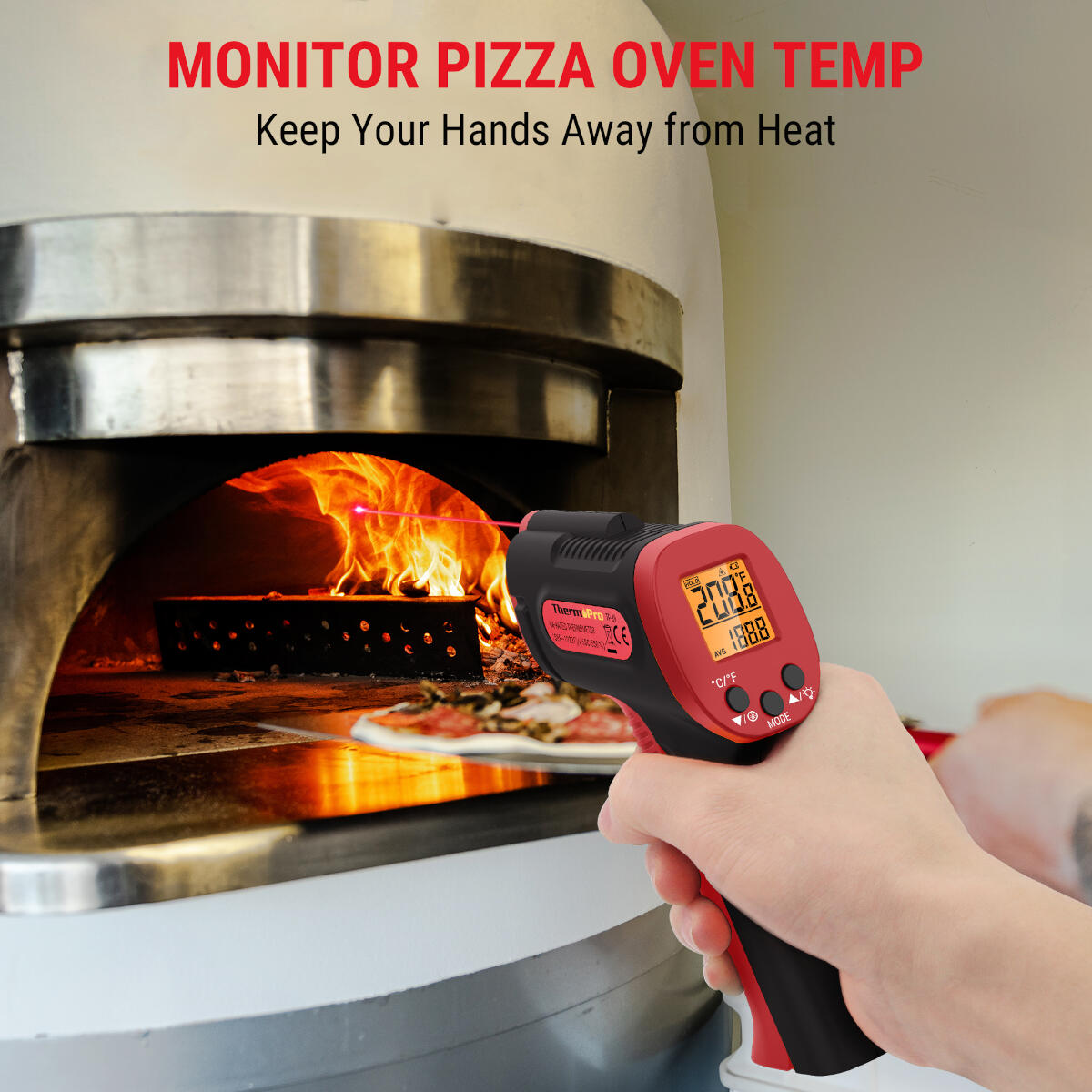 A hand holds a red and black thermometer, measuring the temperature inside a pizza oven. The oven is hot, with a pizza visible.