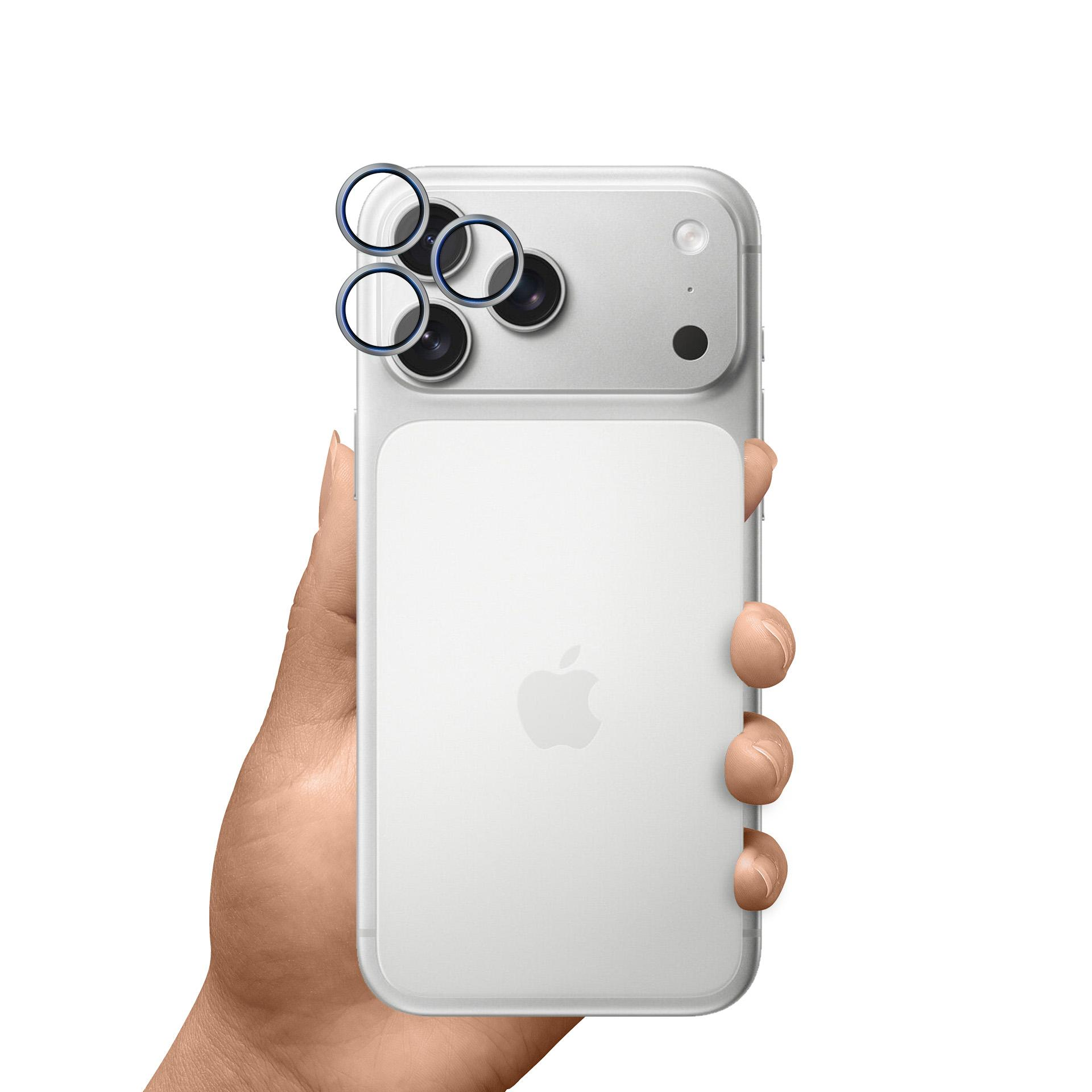 Una mano che tiene un iPhone bianco con un proteggi obiettivo a tripla fotocamera.