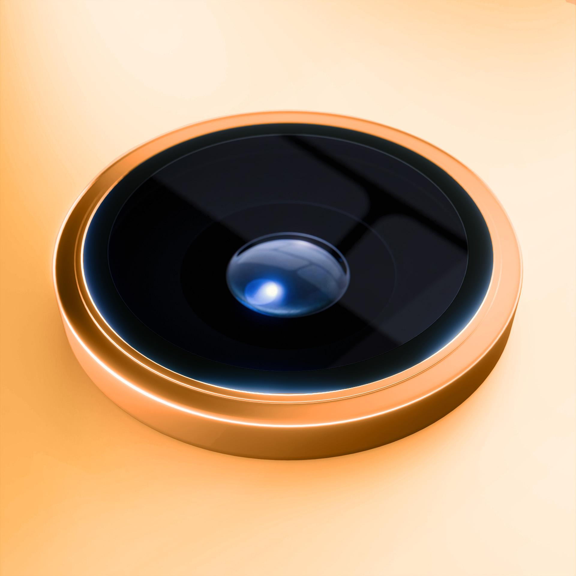 Primo piano dell'obiettivo di una fotocamera del telefono. Ha un anello dorato attorno a una lente scura e circolare. Lo sfondo è giallo.