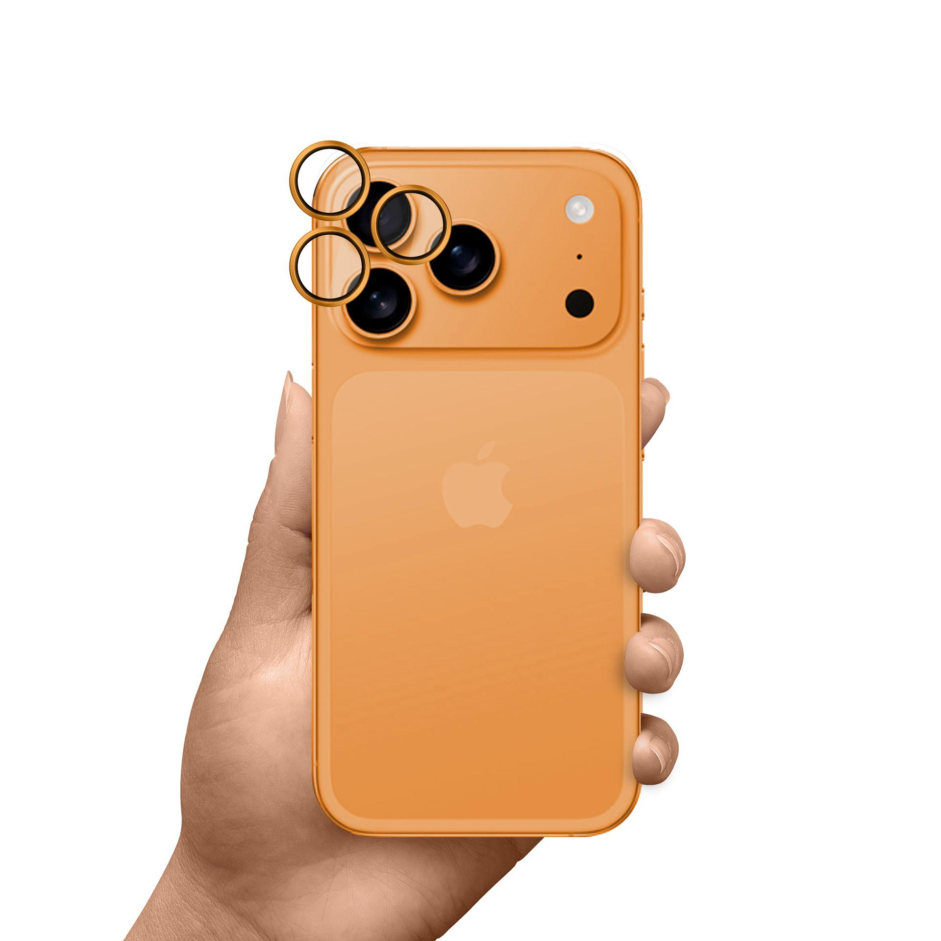 Una mano che tiene un iPhone arancione. Il telefono ha tre obiettivi. Lo sfondo è bianco.