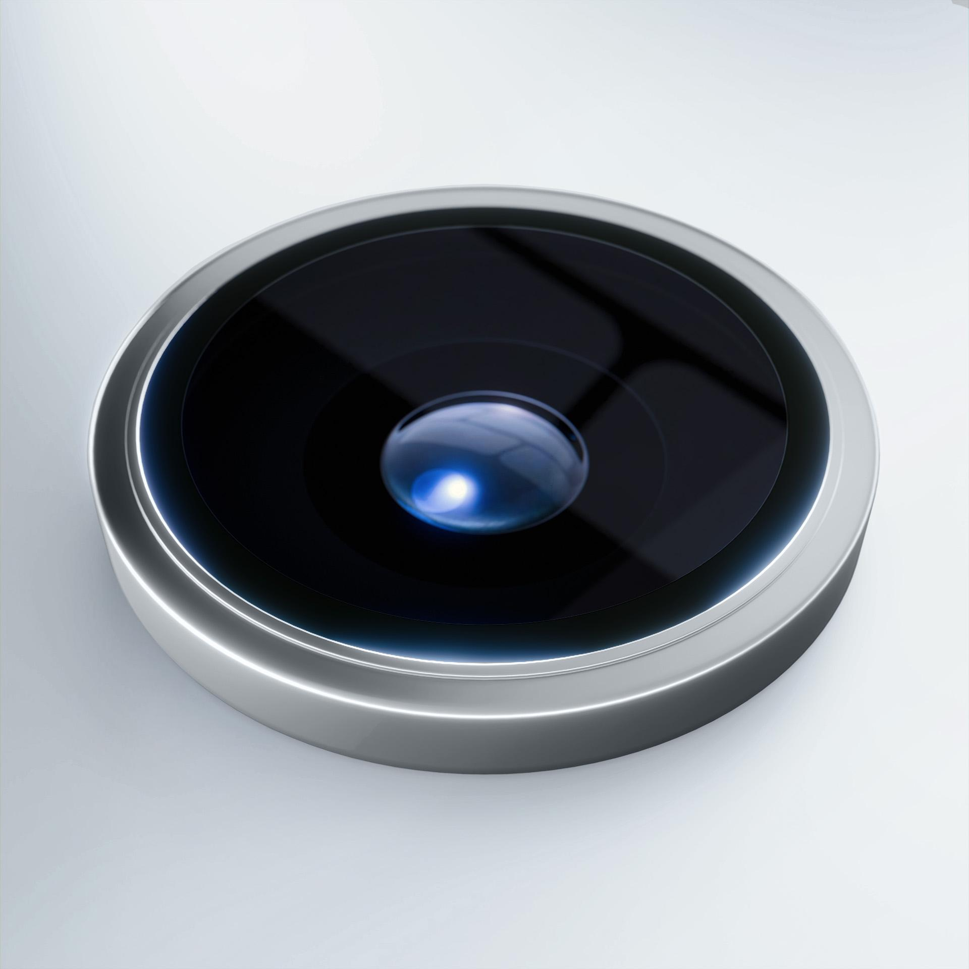 Primo piano dell'obiettivo di una fotocamera del telefono. Ha un centro nero con un riflesso di luce blu e un anello d'argento.