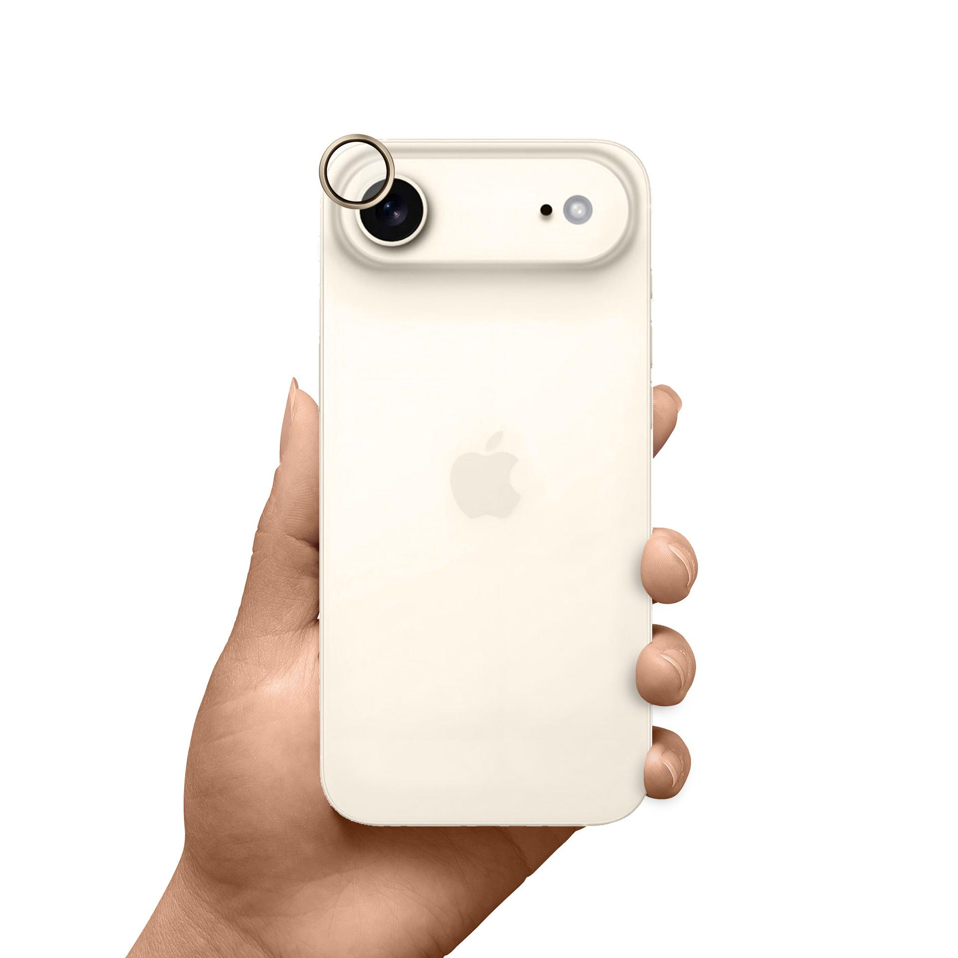 Un iPhone color crema tenuto in mano. Ha un anello per la fotocamera e un logo Apple. Lo sfondo è bianco.
