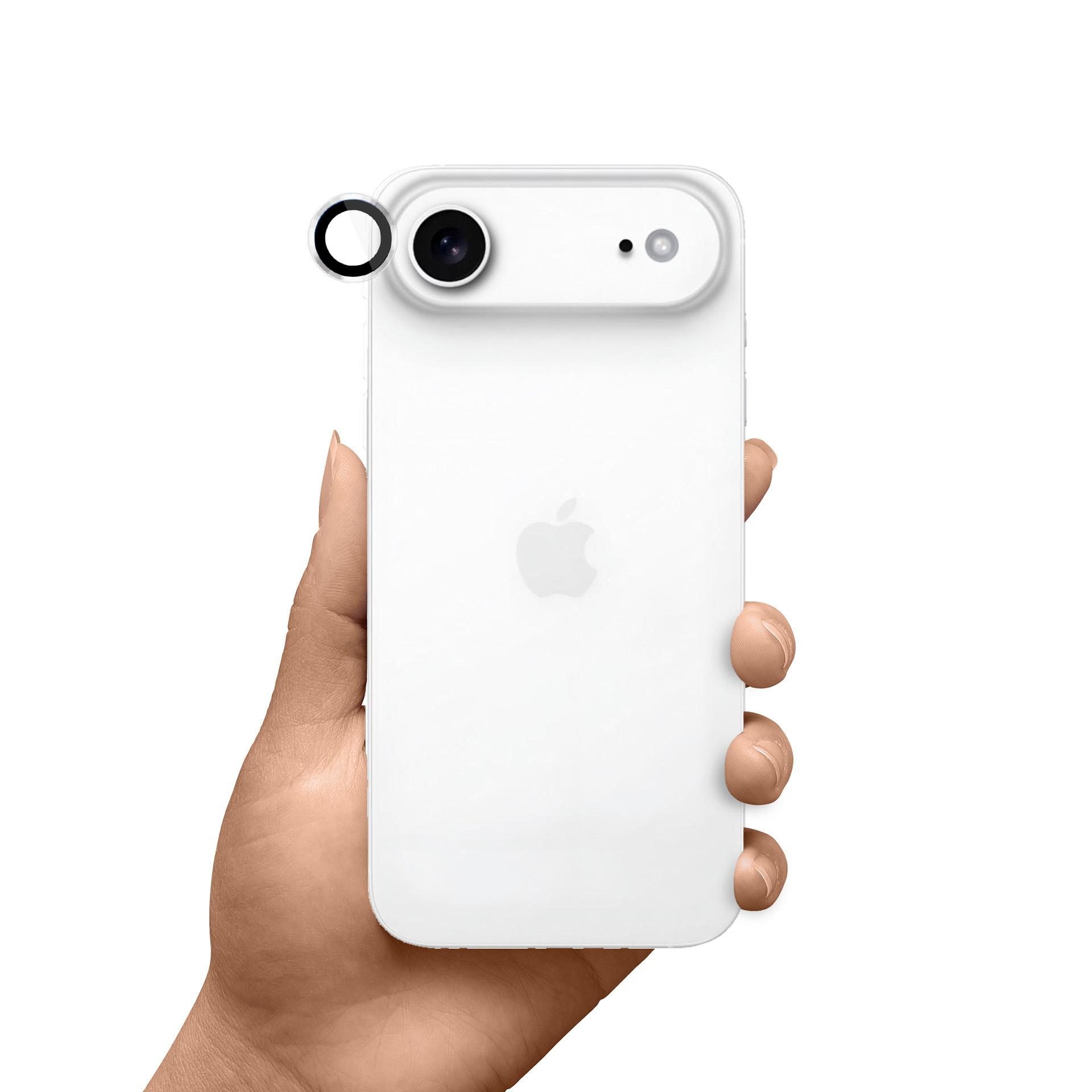 Biały telefon z czarnym obiektywem trzymany w dłoni. Telefon ma logo Apple na plecach.
