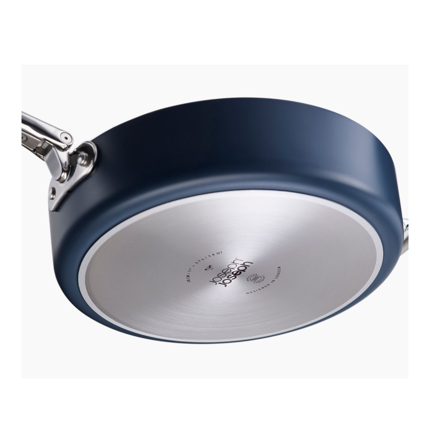 Una olla azul, vista inferior. La parte inferior es plateada con texto. Las asas son plateadas. La olla está sobre un fondo blanco.