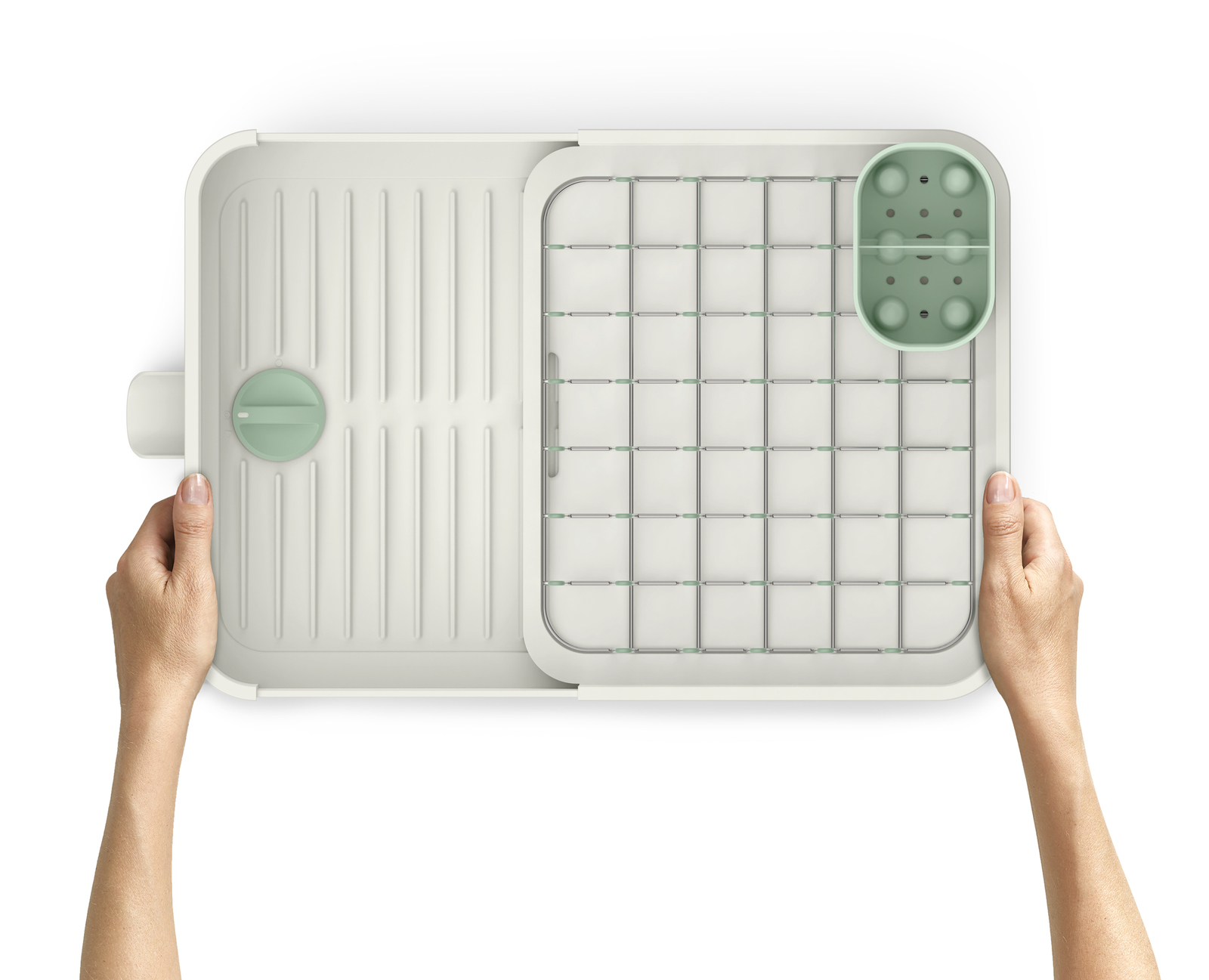 Vista superior de un escurreplatos blanco y verde sostenido por dos manos. El escurreplatos está dividido en secciones con una rejilla.
