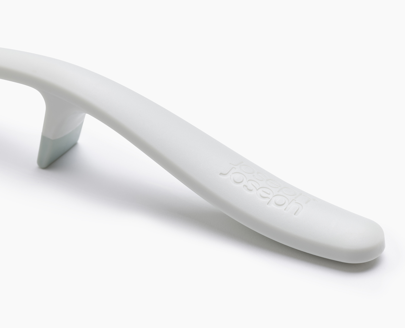 Utensilio de cocina blanco y curvado con base gris y el nombre de la marca 'Joseph' grabado en el mango, sobre fondo blanco.