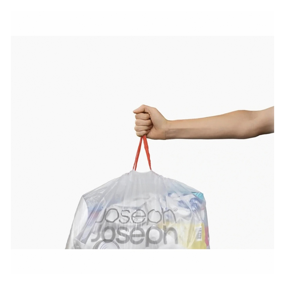 Una mano sostiene una bolsa de plástico transparente llena de objetos. Cuerdas rojas cierran la bolsa. El fondo es blanco.