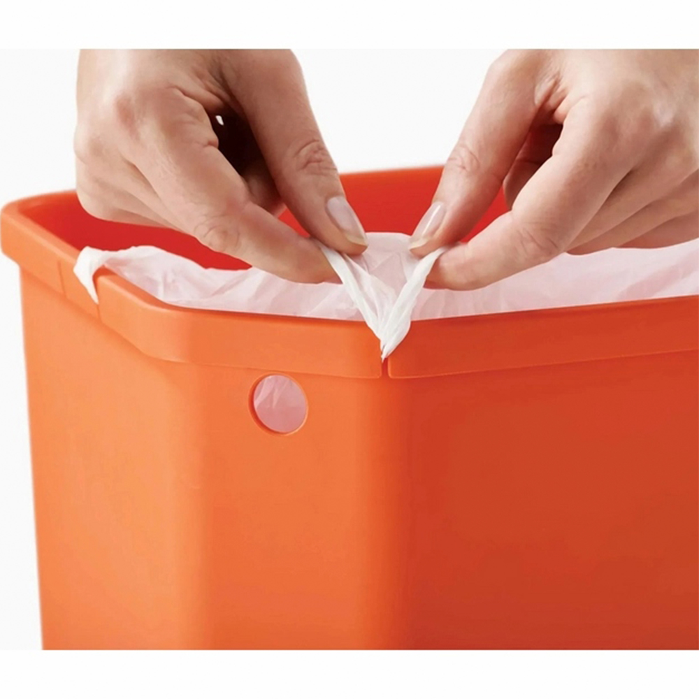 Manos tirando de una bolsa de basura blanca de un cubo naranja. La bolsa está dentro del cubo. El cubo tiene un agujero.