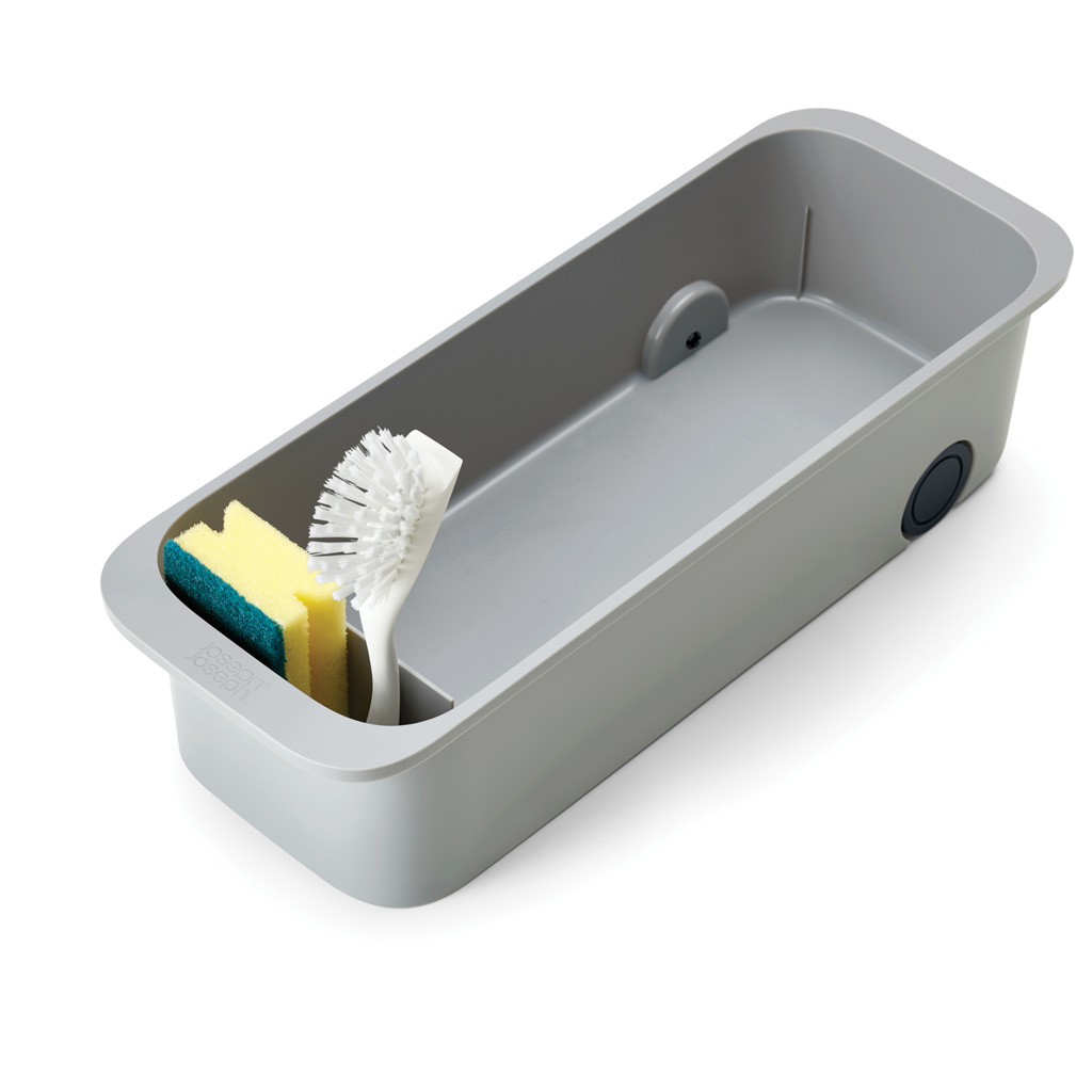 Un organizador de fregadero rectangular gris con una esponja, un cepillo y un orificio de drenaje. La esponja es amarilla y verde.