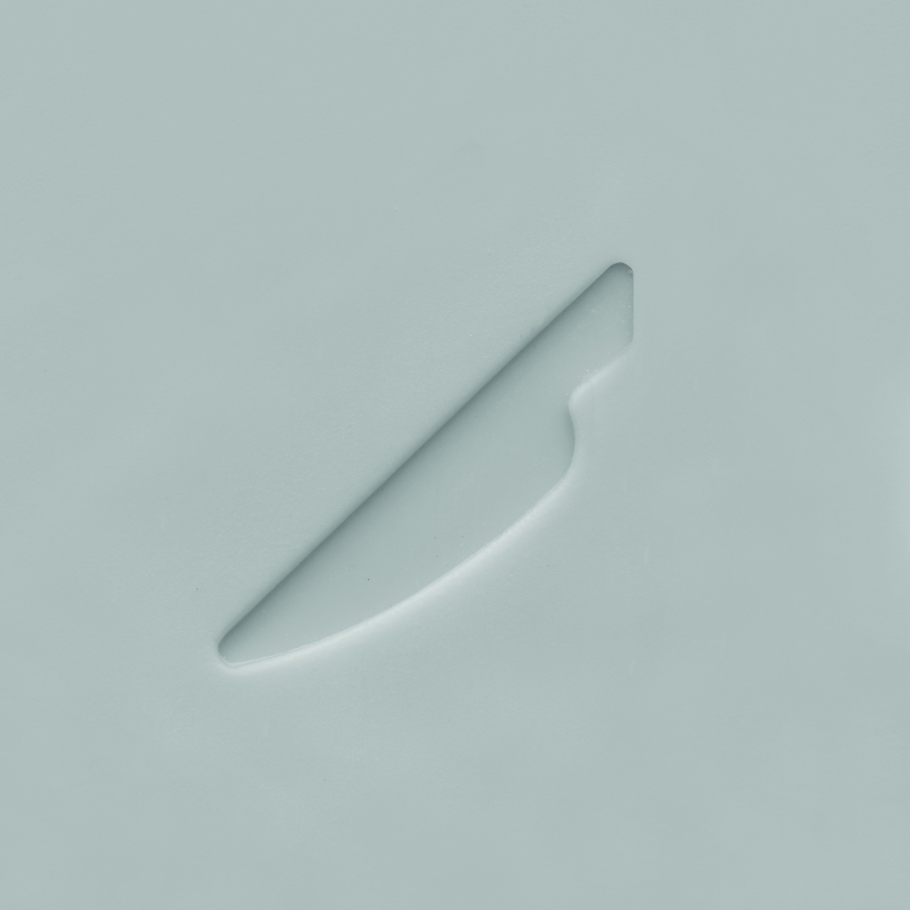 Un cuchillo de plástico blanco yace sobre una superficie blanca. El cuchillo está en ángulo, mostrando los detalles de la hoja y el mango.