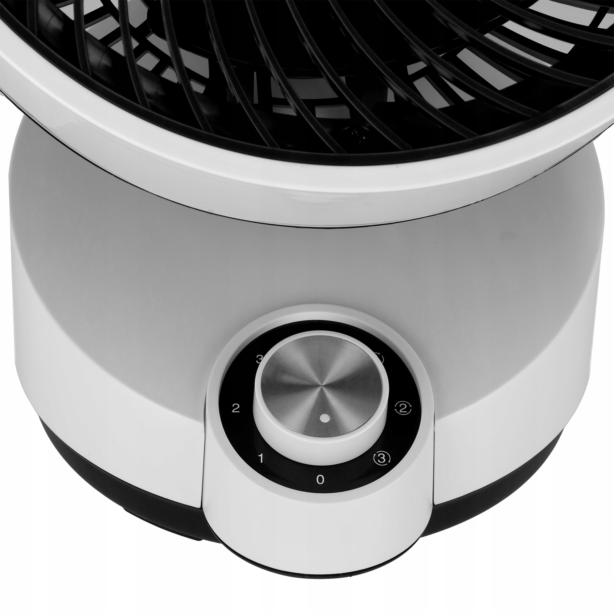 Zbliżenie białego wentylatora z czarną kratką. Srebrne pokrętło z cyframi 0-3 kontroluje prędkość.