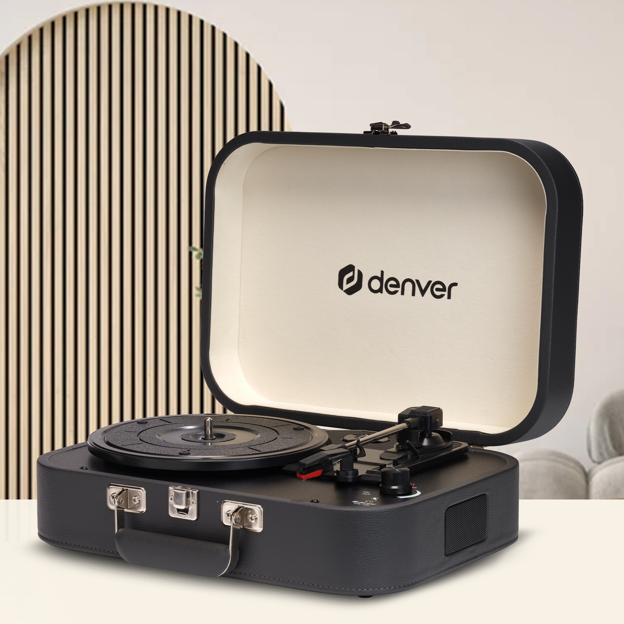 Tourne-disque noir avec couvercle ouvert, marque Denver, sur une surface blanche. Panneau en lattes de bois en arrière-plan.