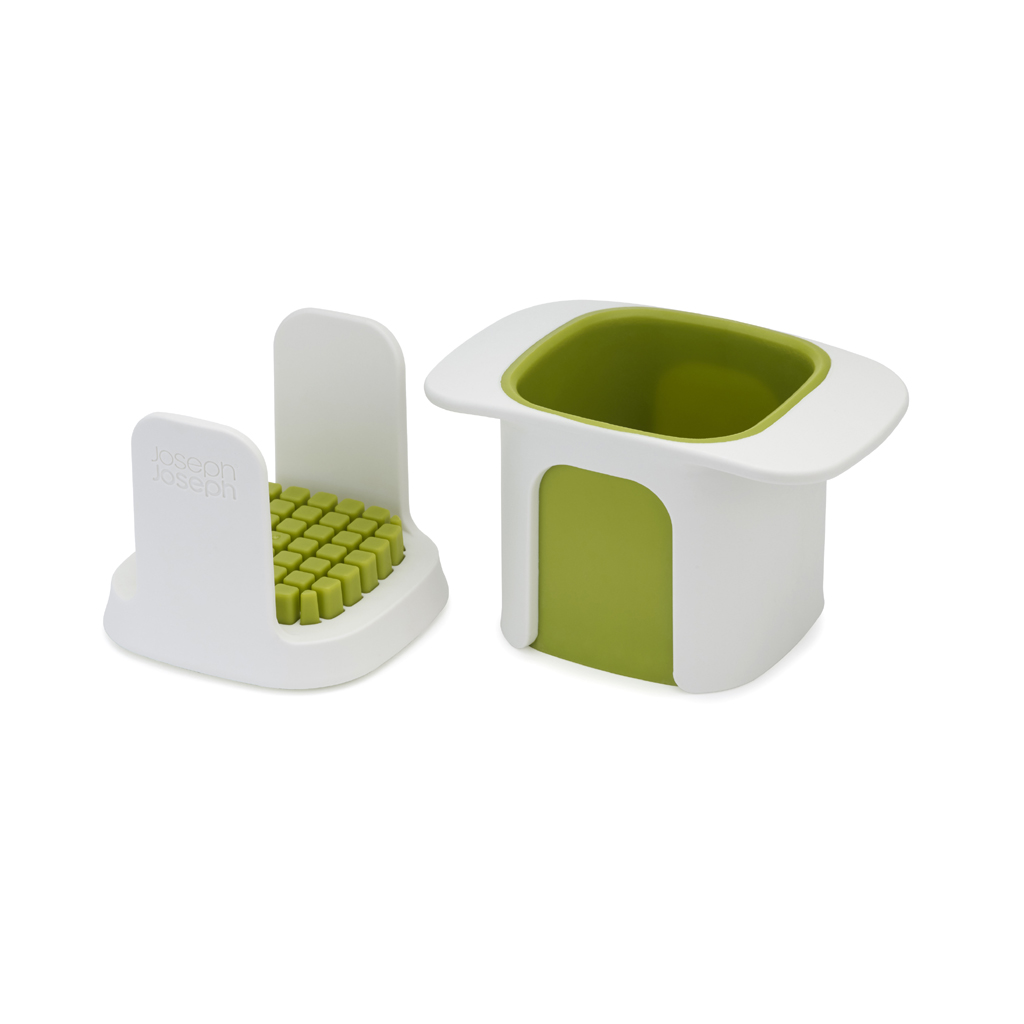 Gadget de cocina blanco y verde con una rejilla de corte y un recipiente. El recipiente tiene una abertura cuadrada e interior verde.