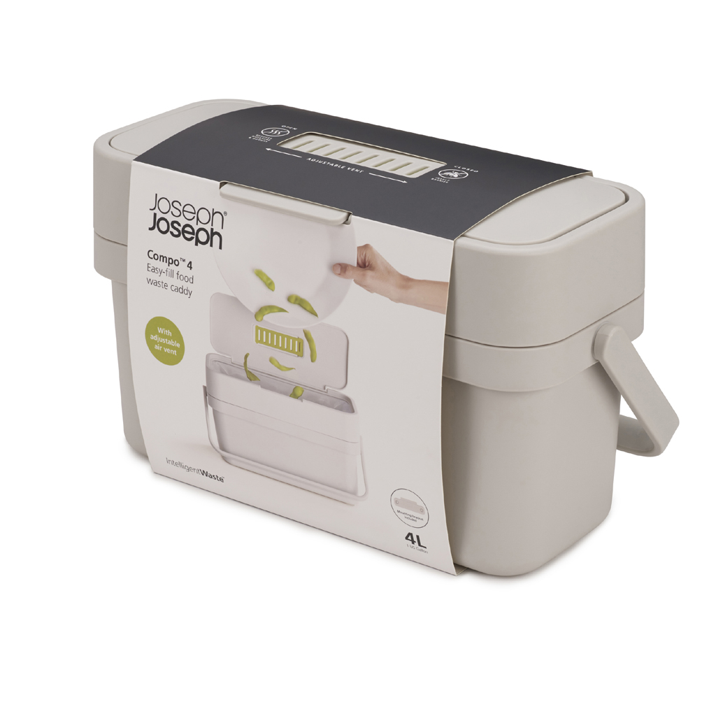 Un cubo de basura para alimentos gris Joseph Joseph Compo 4 con tapa abierta. Se muestran verduras verdes que se colocan dentro. Tiene un asa.