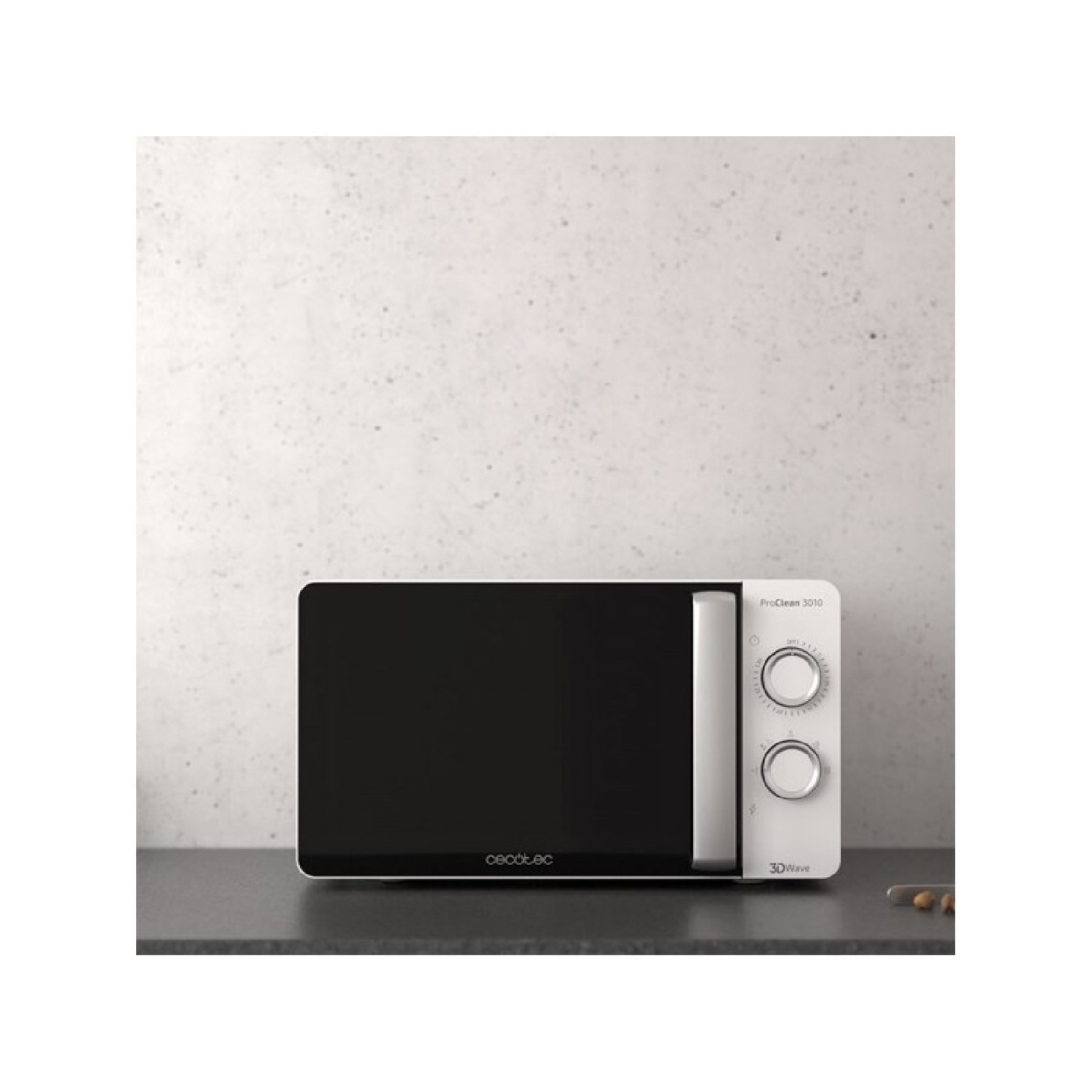 Biała kuchenka mikrofalowa z czarnymi drzwiami stoi na ciemnym blacie na tle nakrapianej szarej ściany. To Cecotec ProClean 3010.