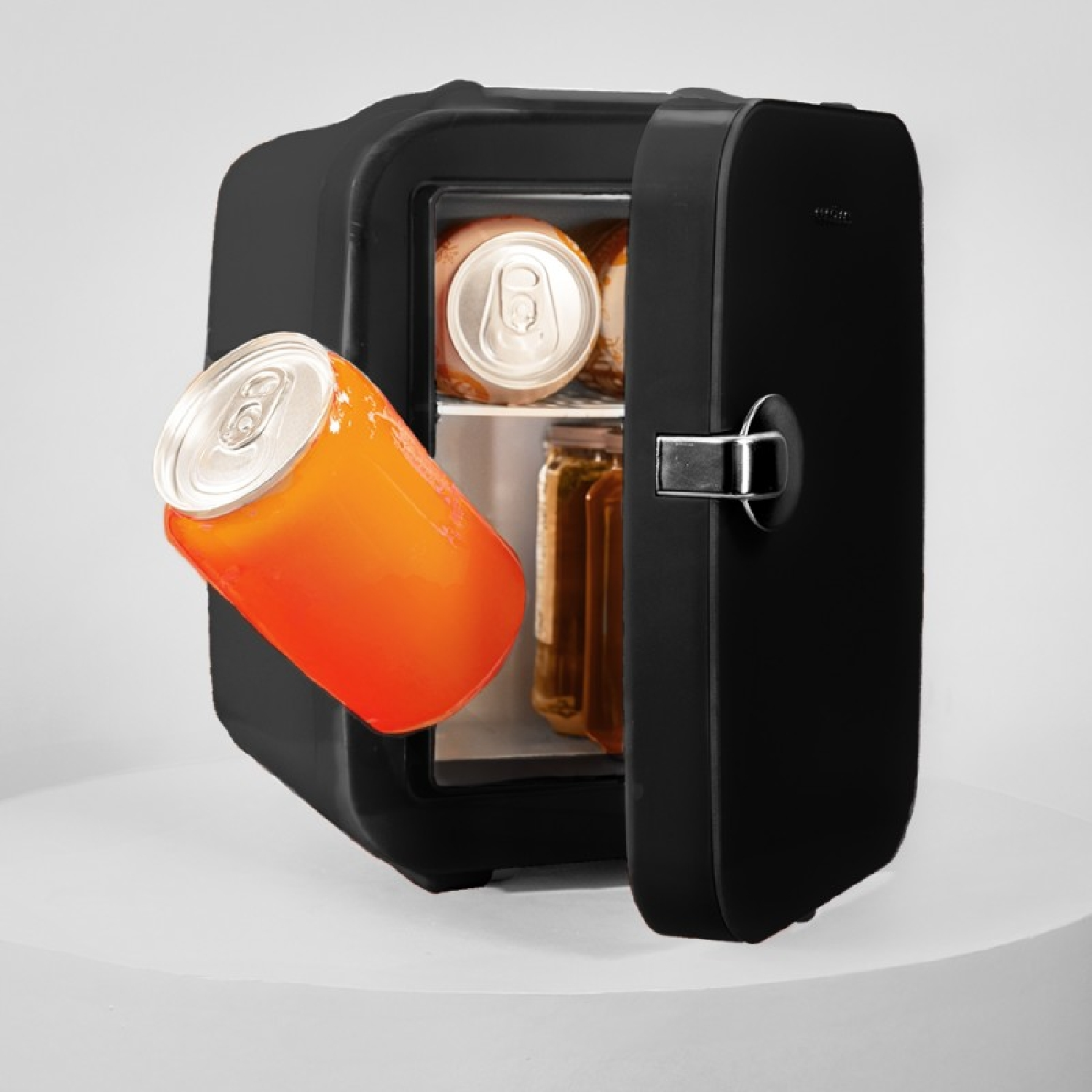 Un mini-refrigerador negro con la puerta abierta. Hay una lata naranja en primer plano y otras latas y frascos dentro.